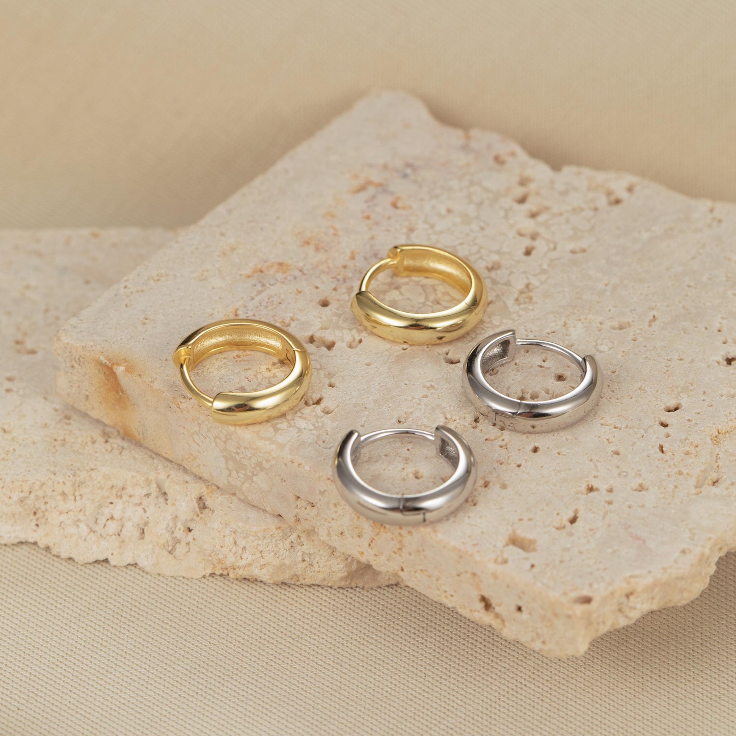 three gold and silver rings sitting on a rock