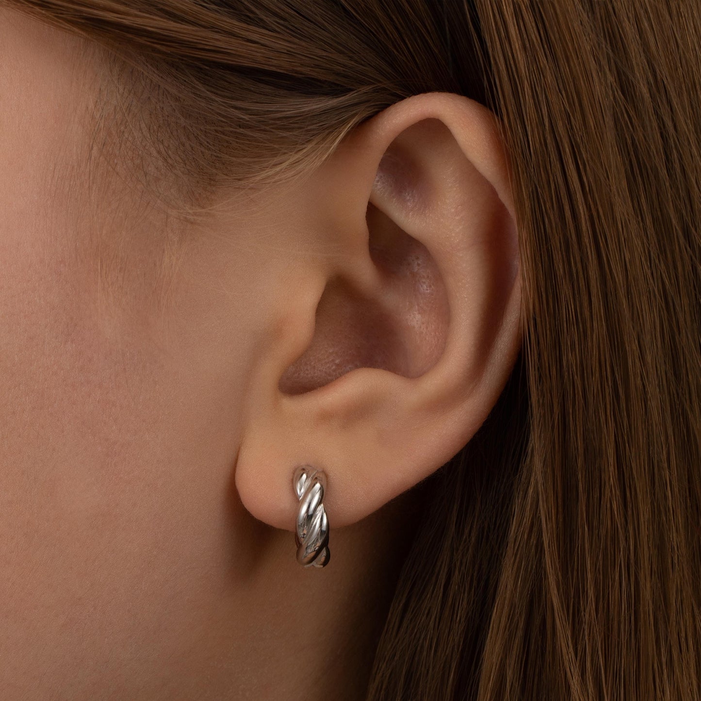 a close up of a person wearing a pair of earrings