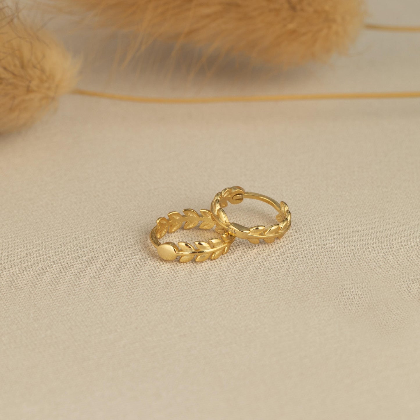 a pair of gold rings sitting on top of a table