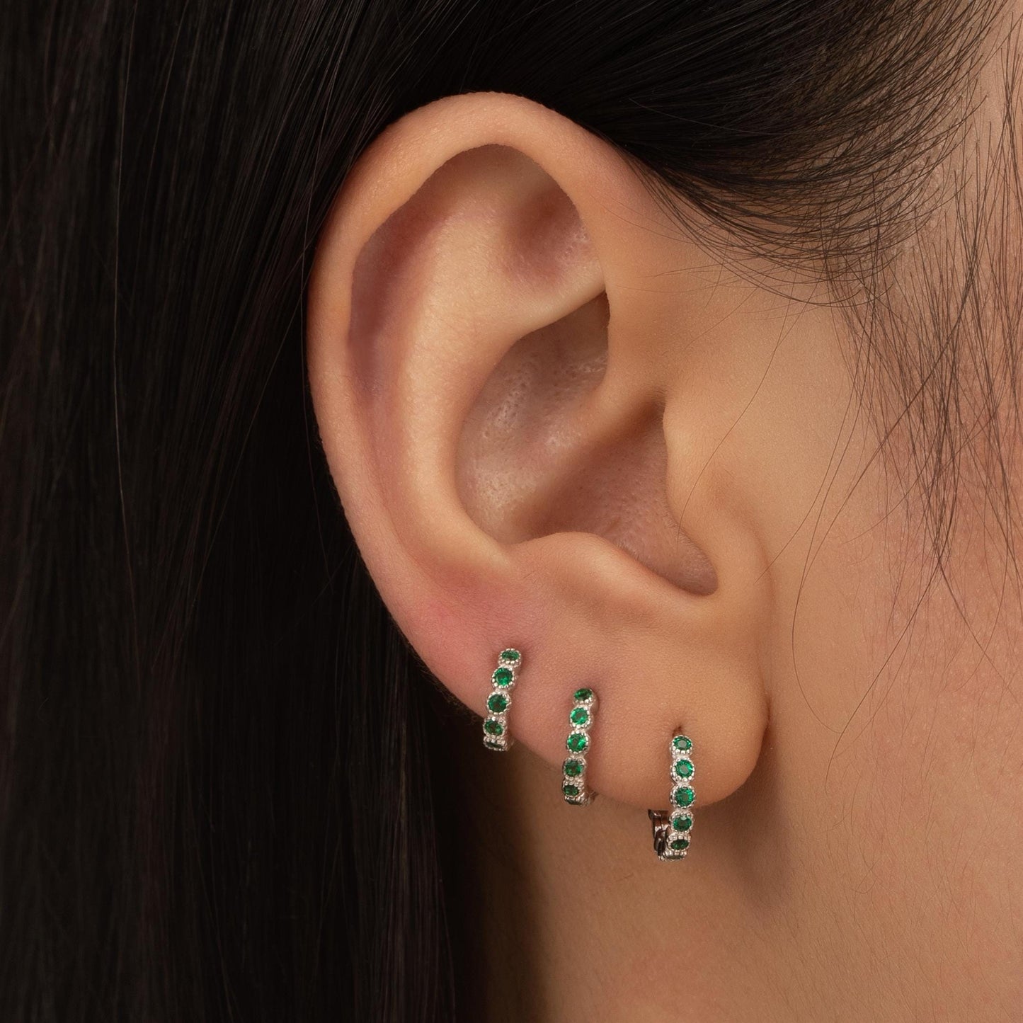 a close up of a person wearing a pair of earrings