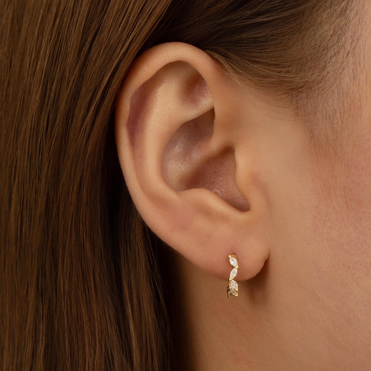 a close up of a person wearing a pair of earrings