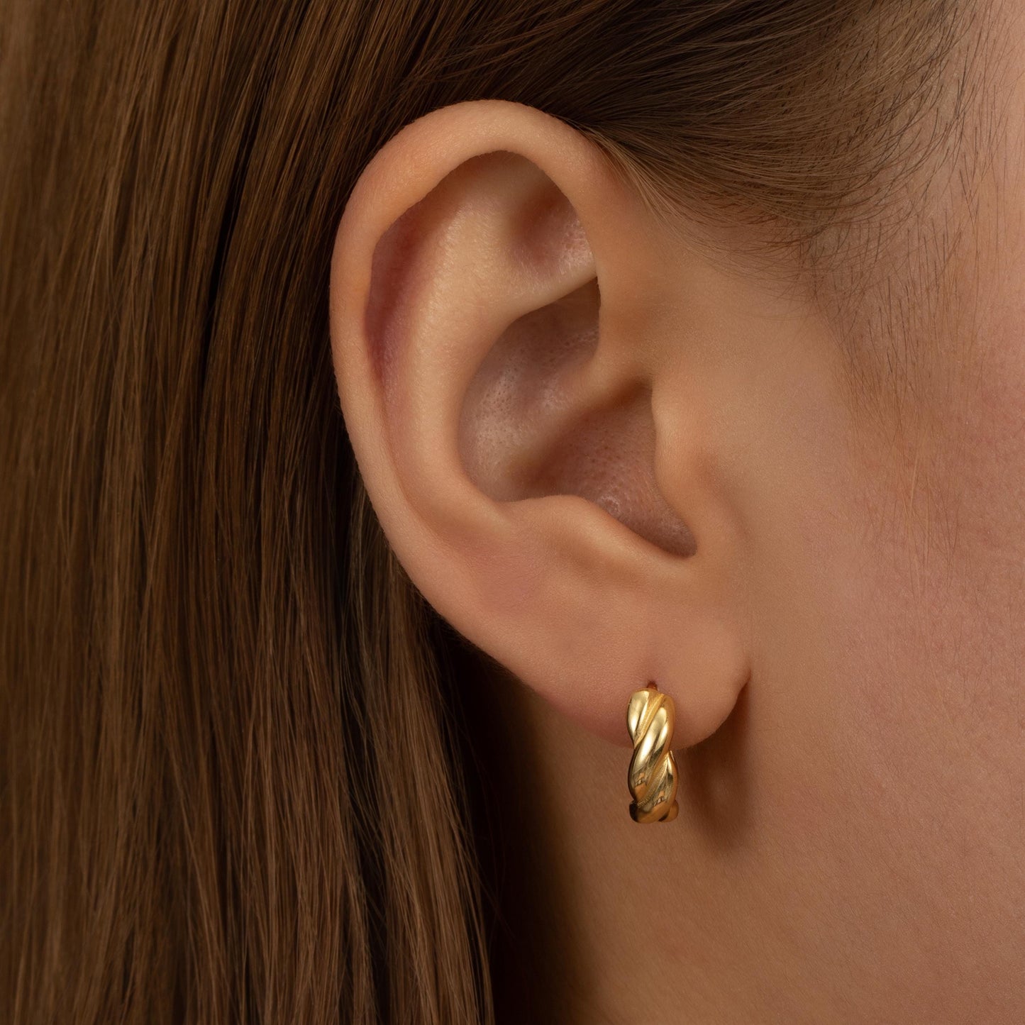 a close up of a person wearing a pair of earrings