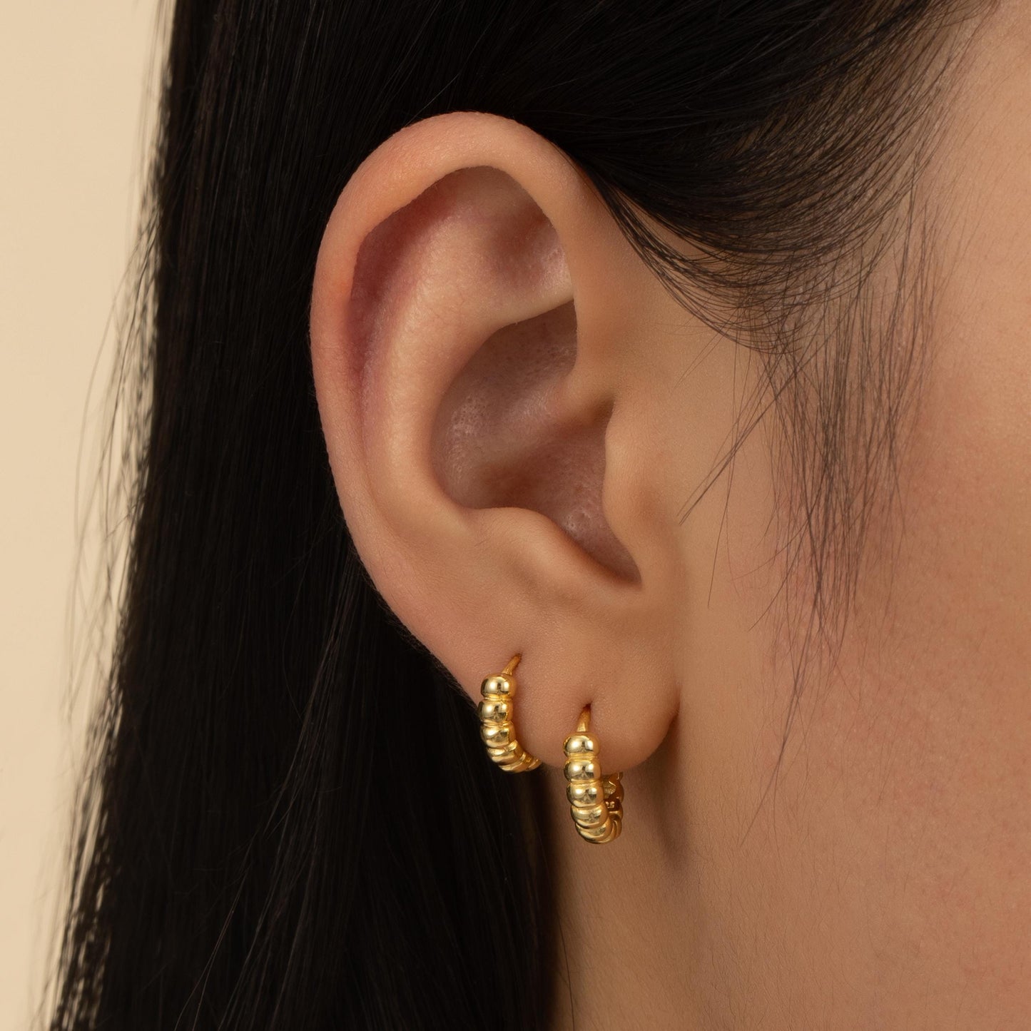 a close up of a person wearing a pair of earrings