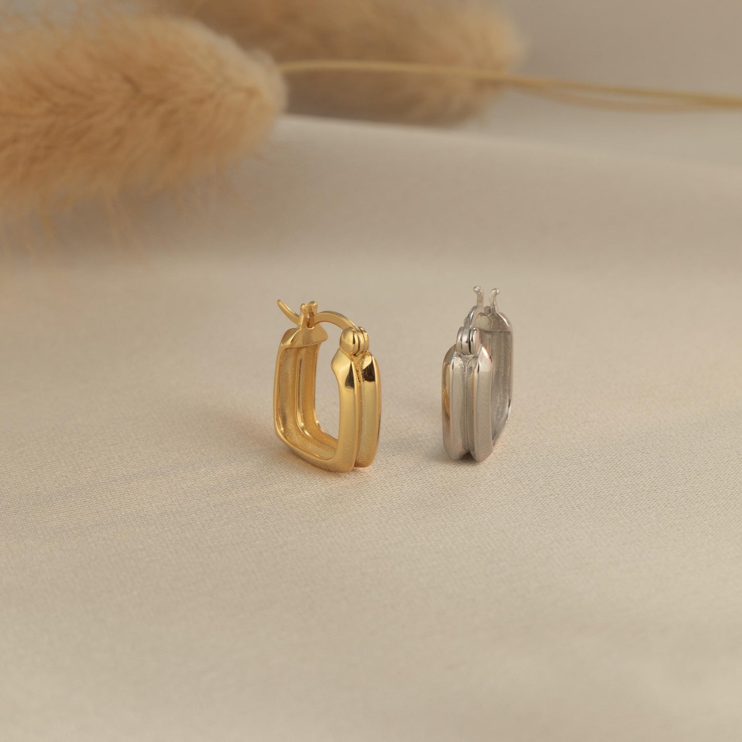 a pair of earrings sitting on top of a white surface