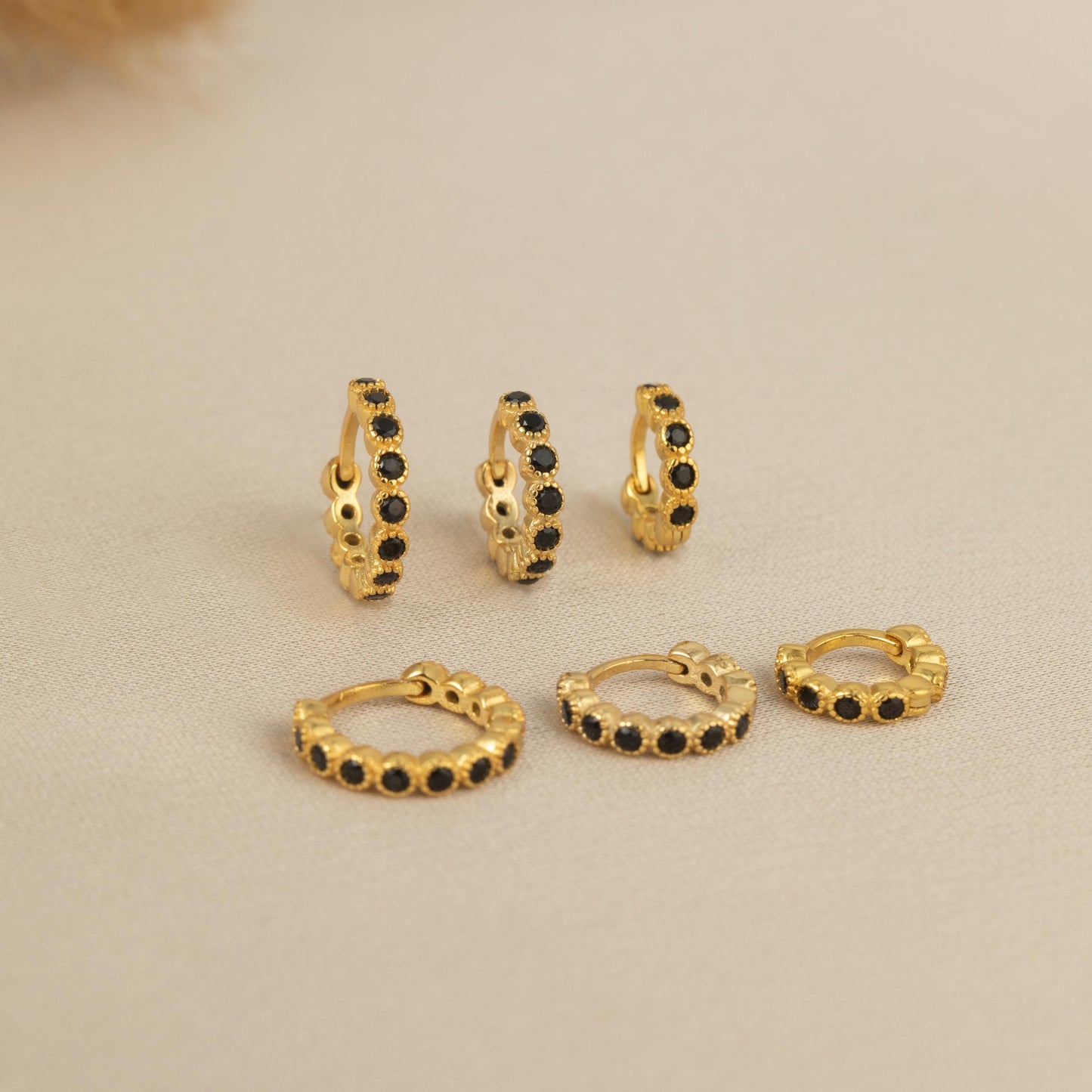 a set of four pairs of gold and black diamond hoop earrings