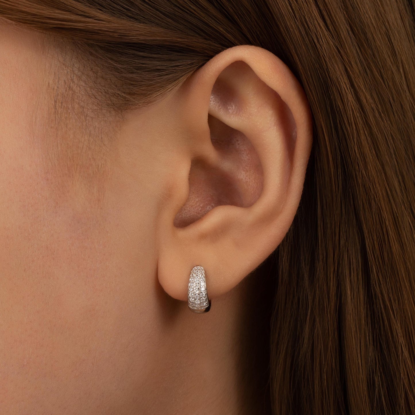 a close up of a person wearing a pair of earrings