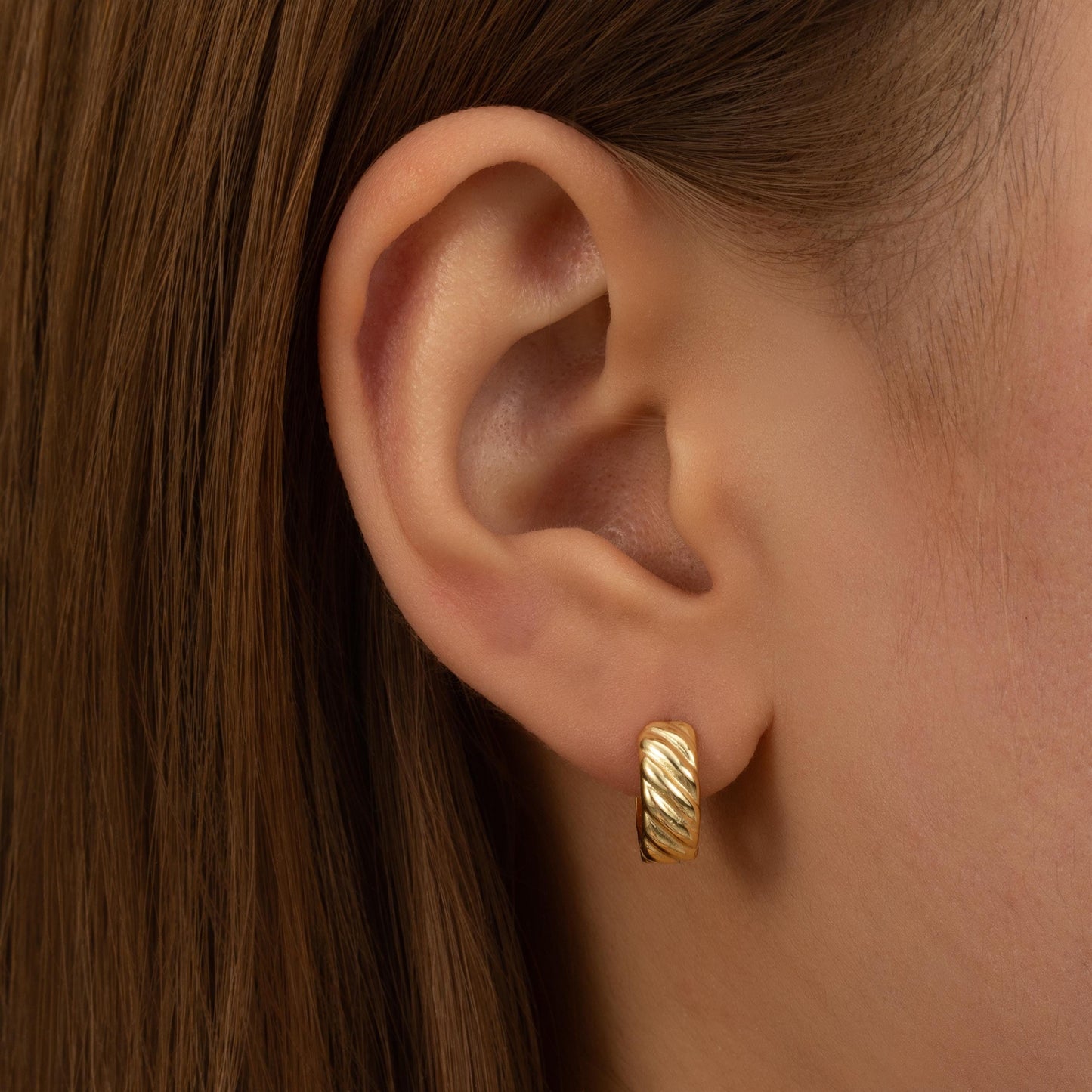 a close up of a person wearing a pair of earrings