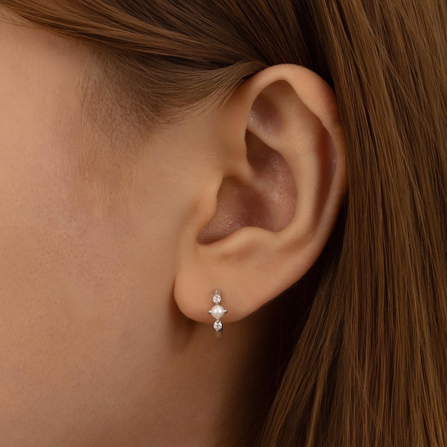 a close up of a person wearing a pair of earrings