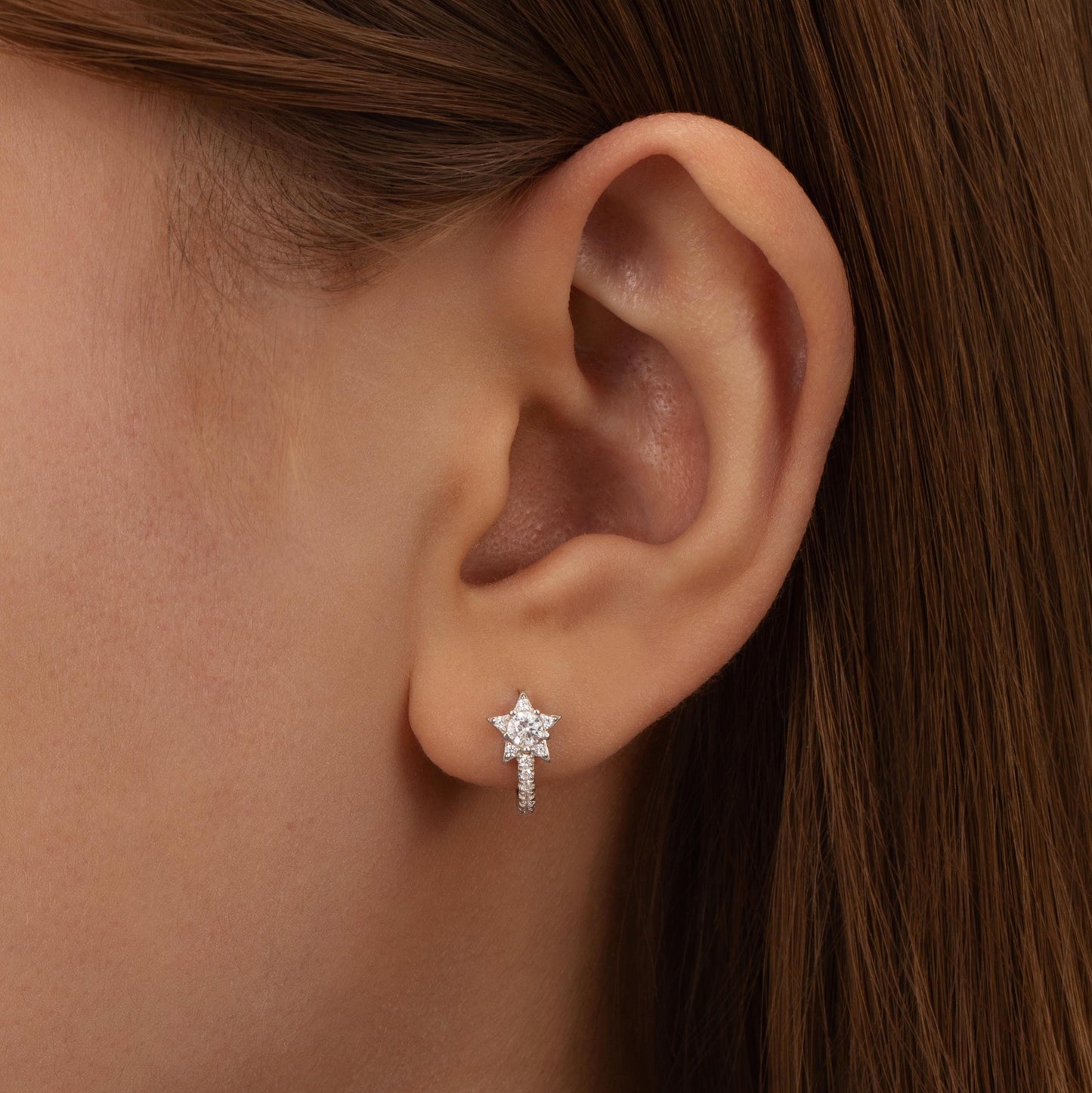 a close up of a person wearing a pair of earrings