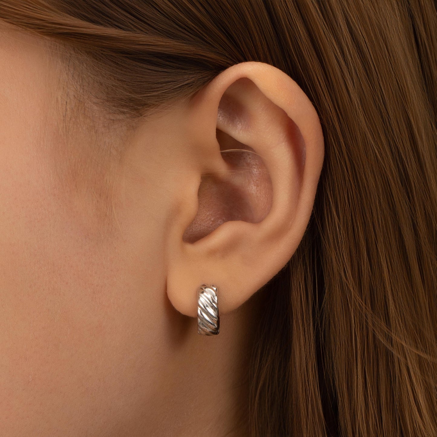 a close up of a person wearing a pair of earrings