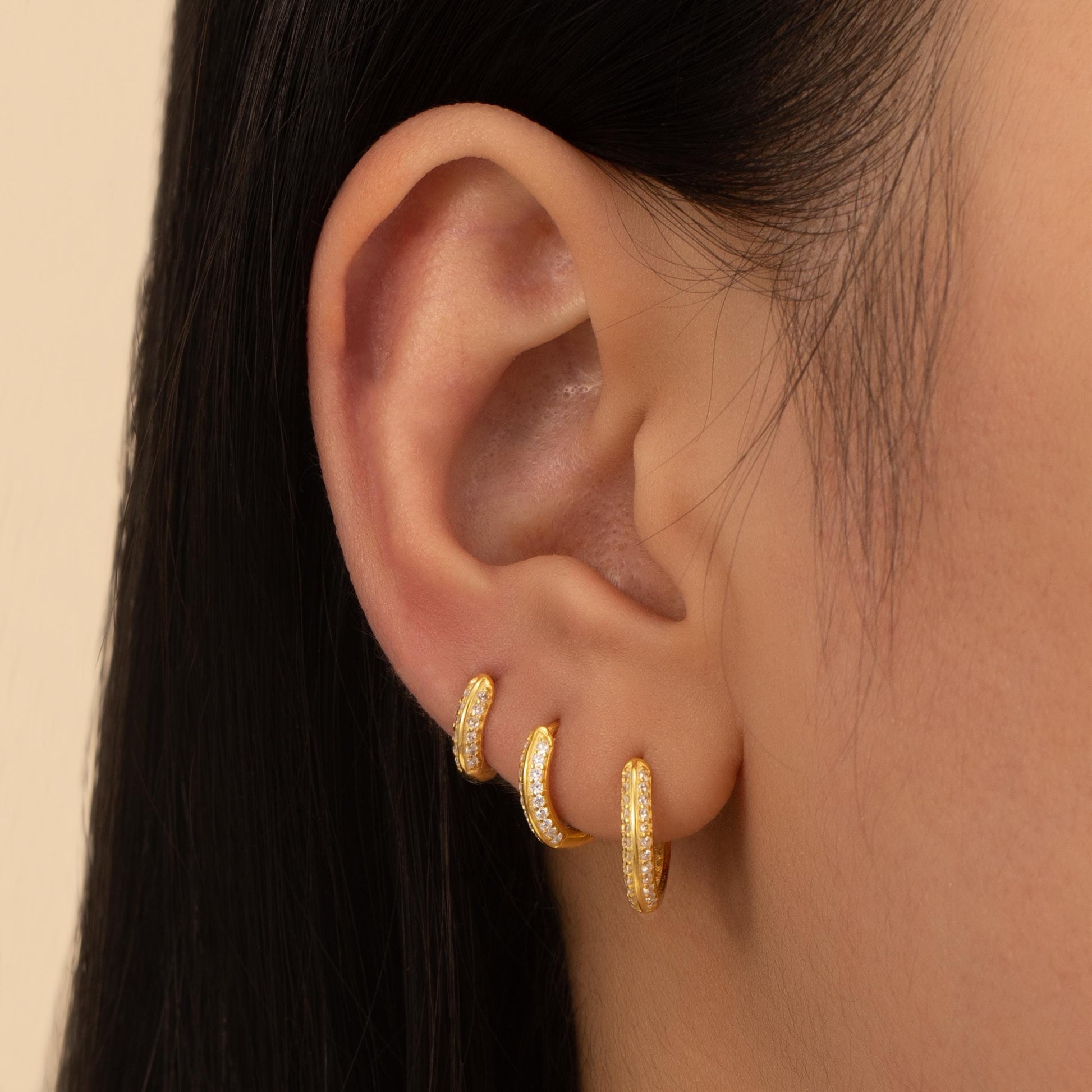 a close up of a person wearing a pair of earrings