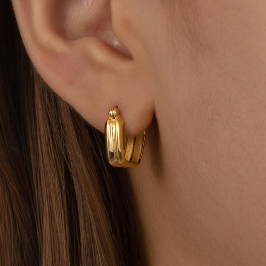 a close up of a person wearing a pair of earrings