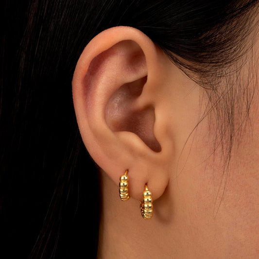 a close up of a person wearing a pair of earrings