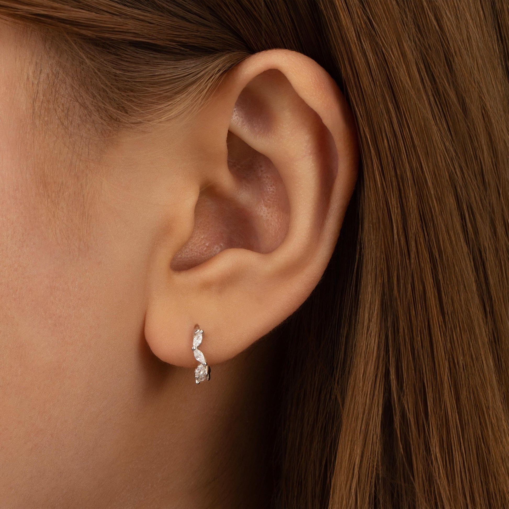 a close up of a person wearing a pair of earrings