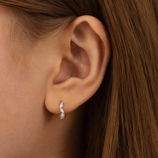 a close up of a person wearing a pair of earrings
