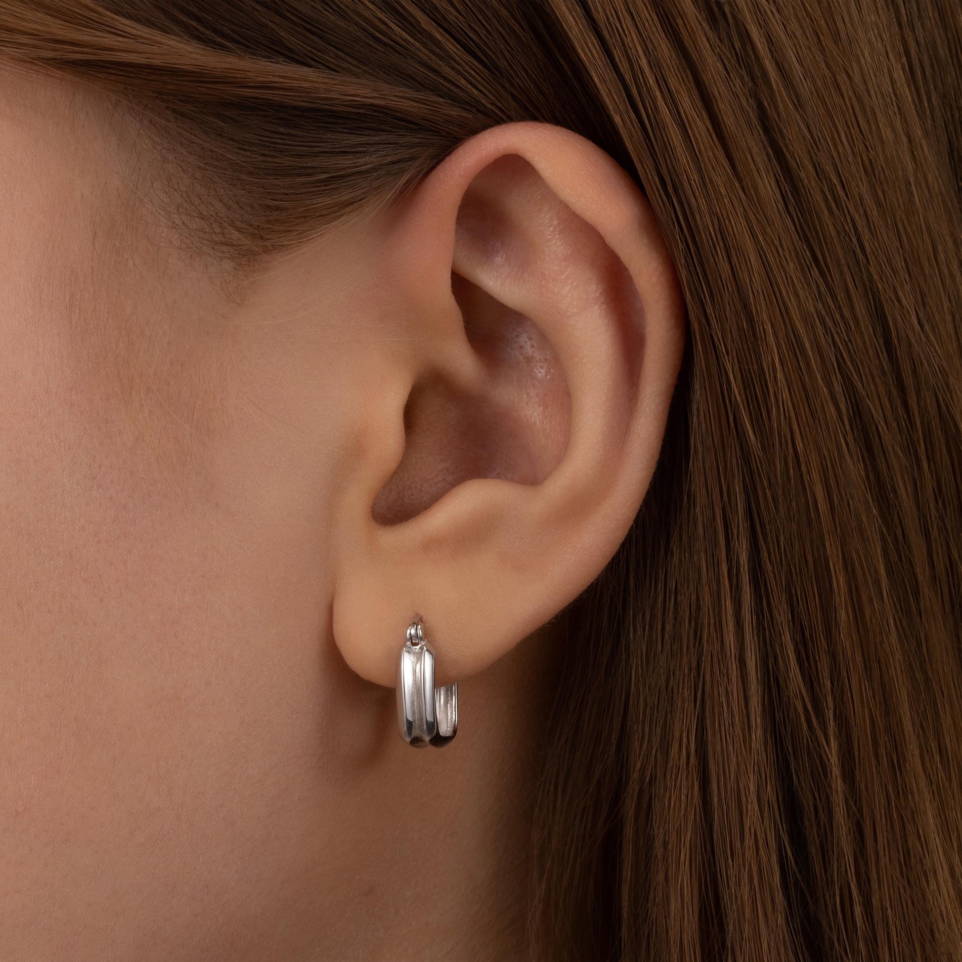 a close up of a person wearing a pair of earrings