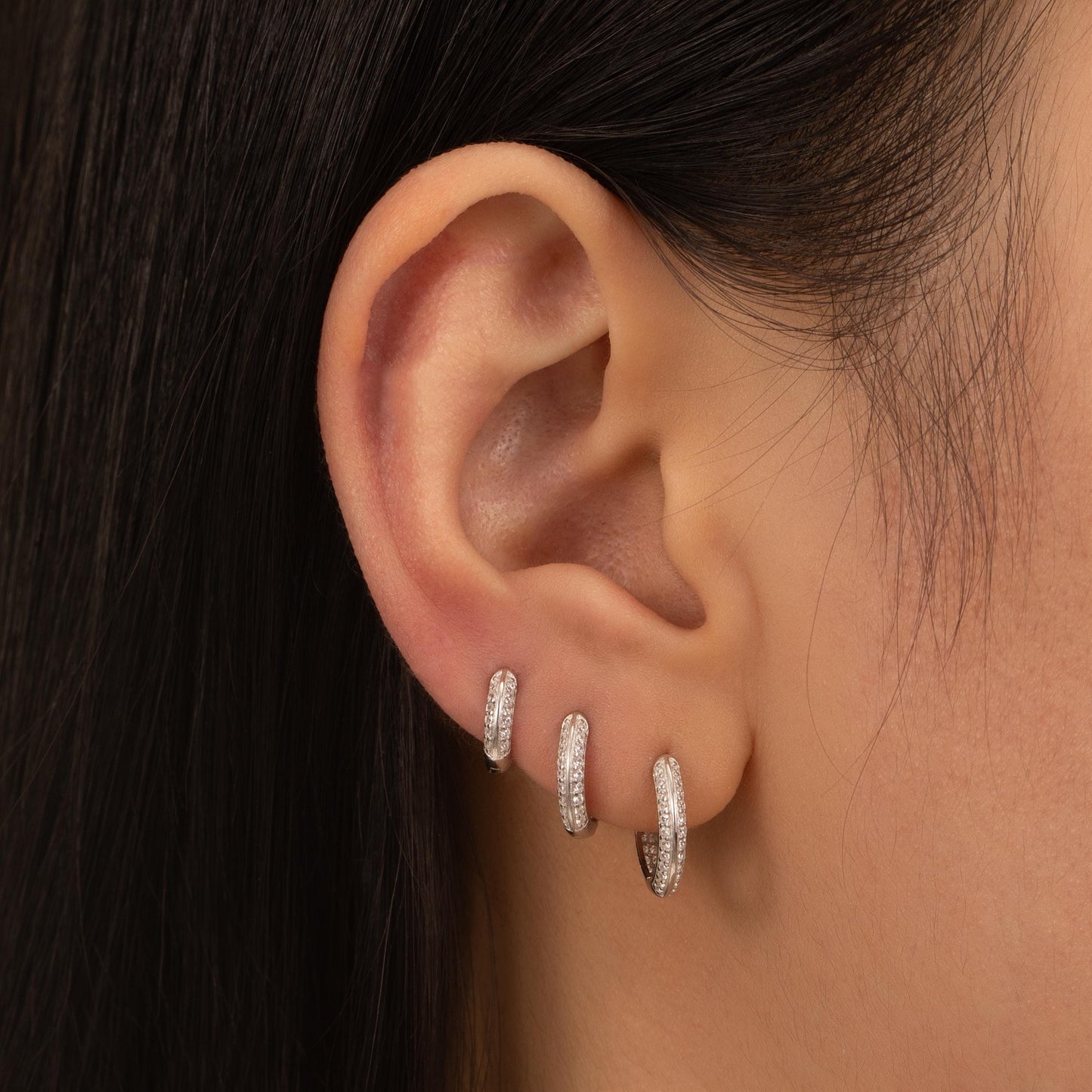 a close up of a person wearing a pair of earrings