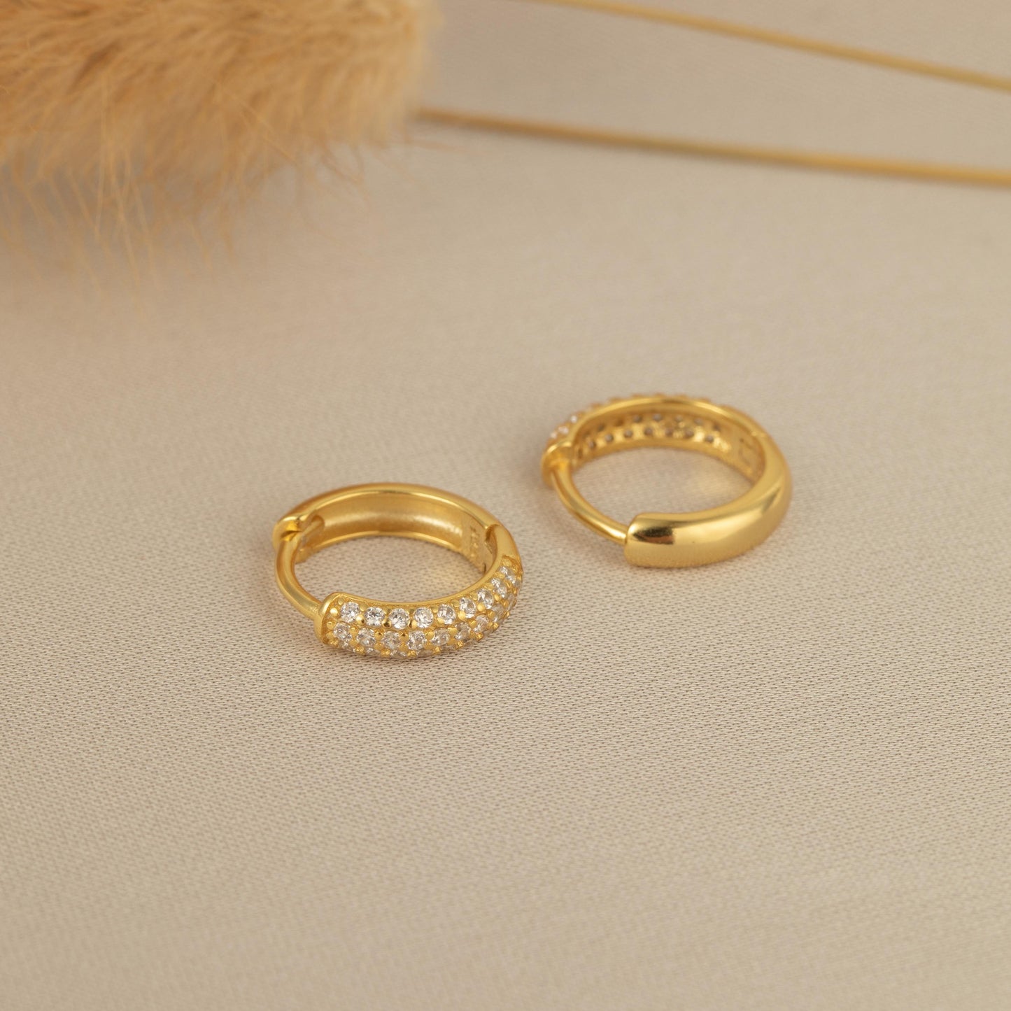 a pair of gold hoop earrings sitting on top of a table