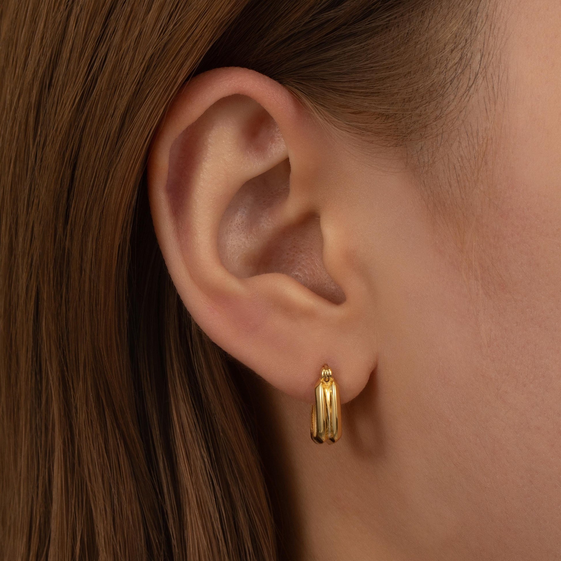 a close up of a person wearing a pair of earrings