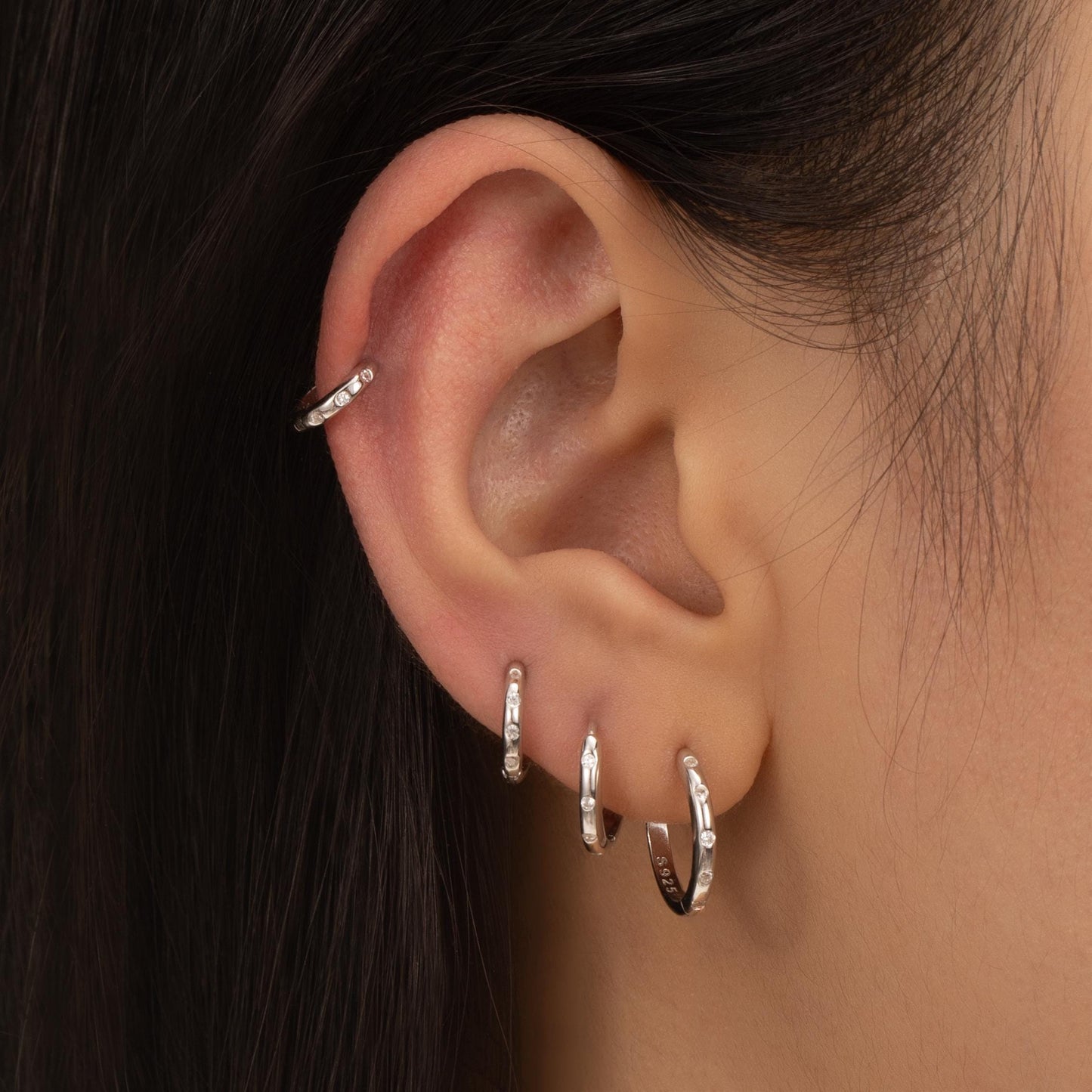 a close up of a person wearing a pair of earrings