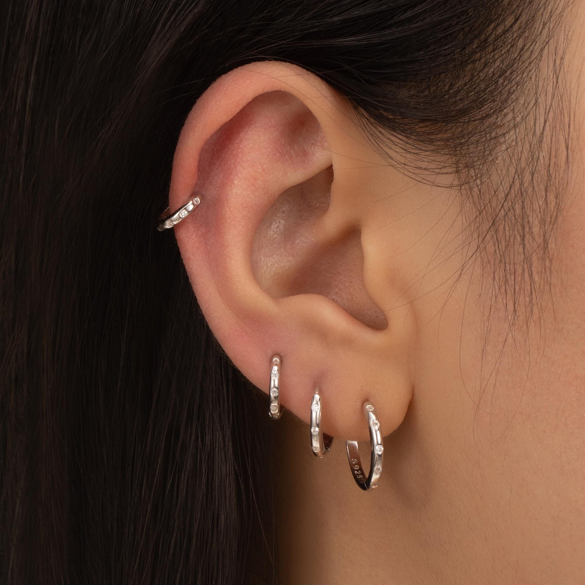 a close up of a person wearing a pair of earrings