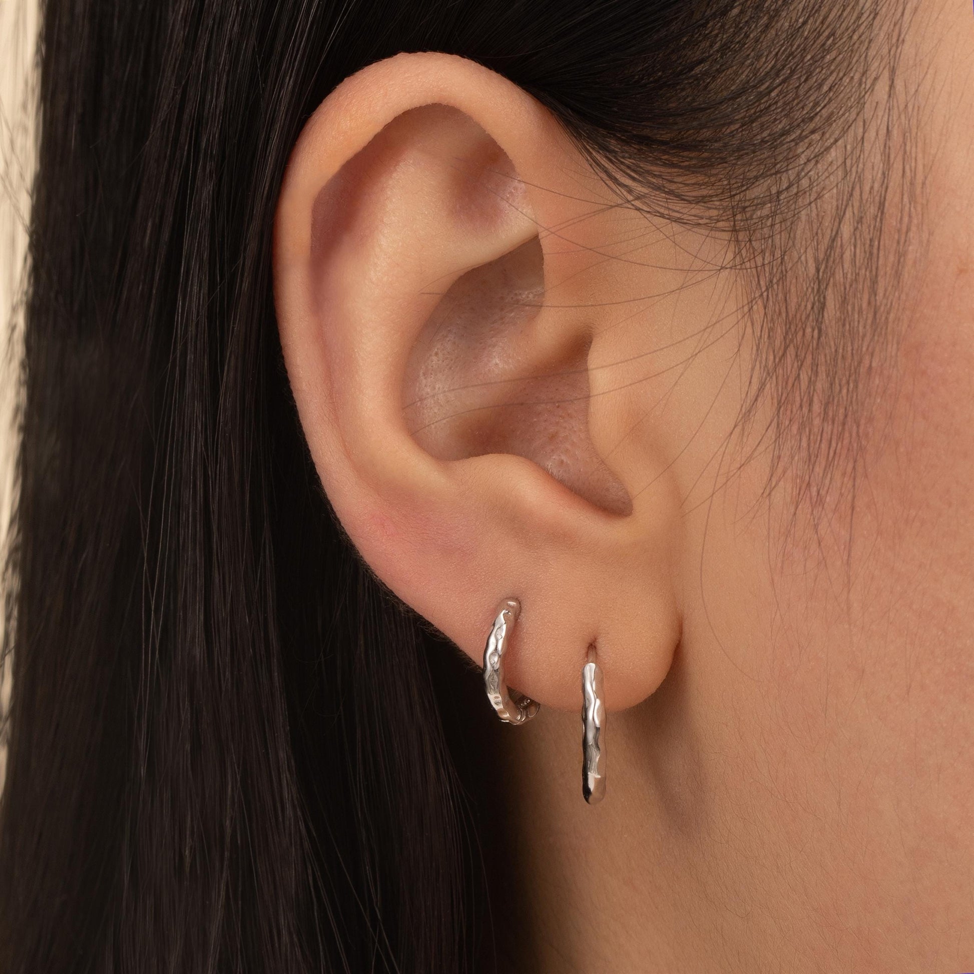 a close up of a person wearing a pair of earrings