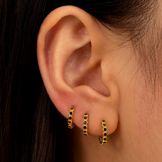 a close up of a person wearing a pair of earrings