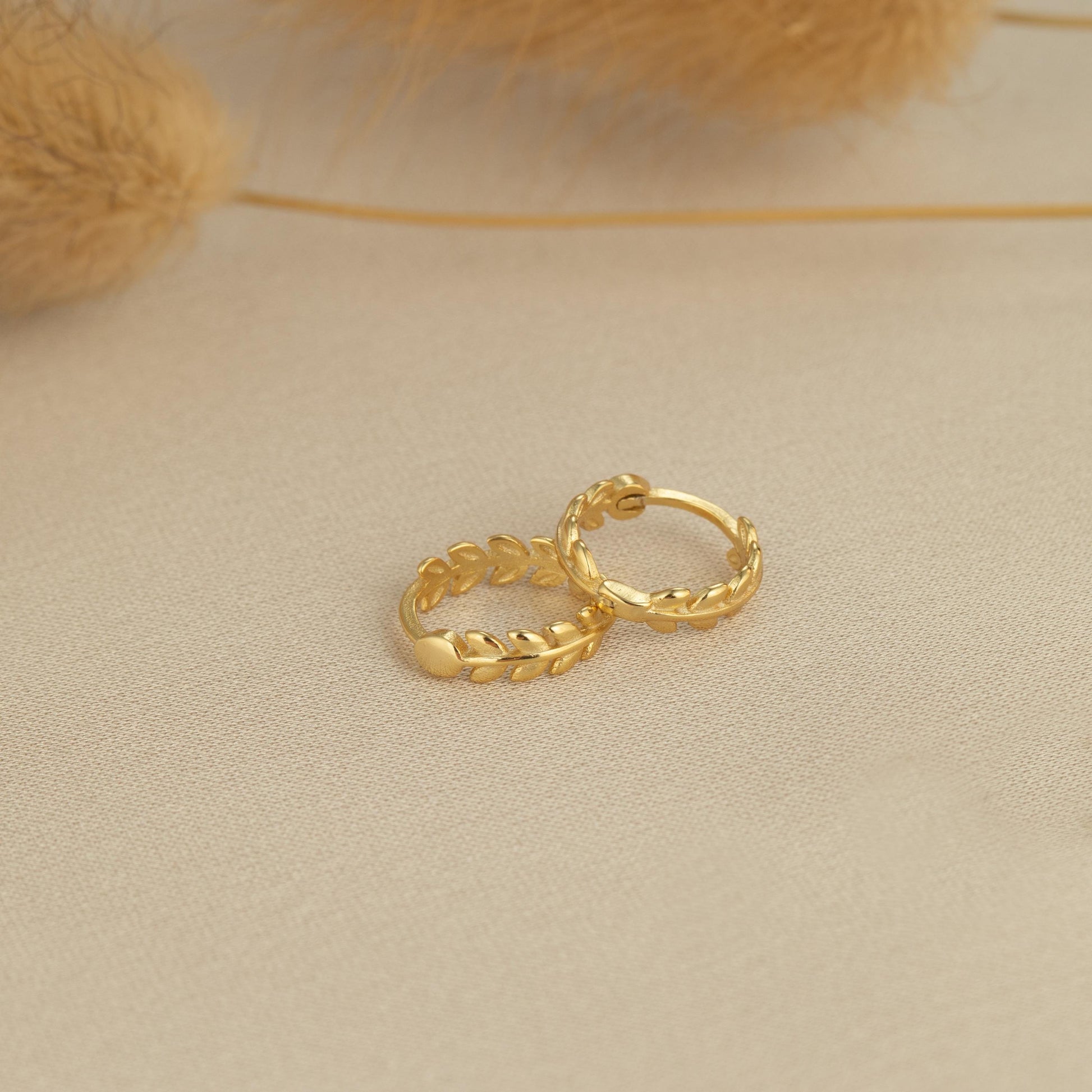 a pair of gold rings sitting on top of a table