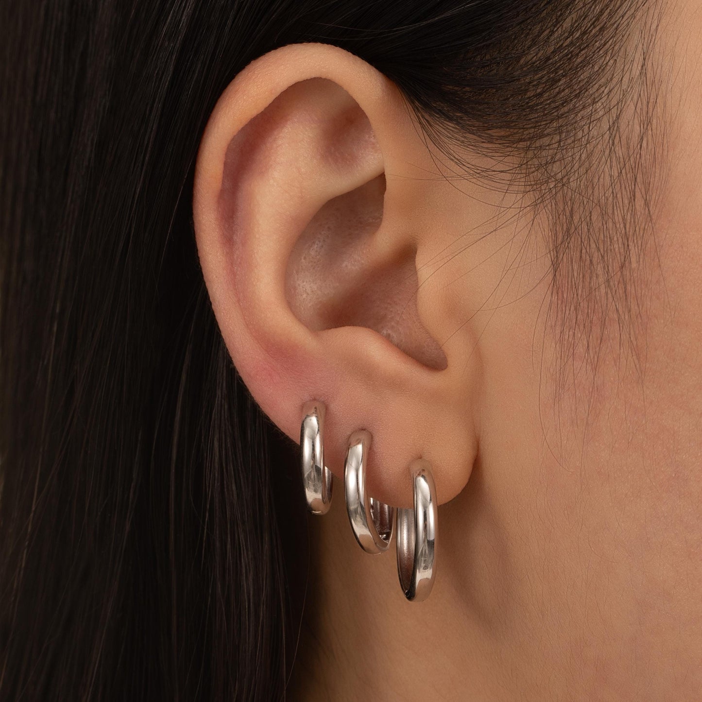 a close up of a person wearing a pair of earrings