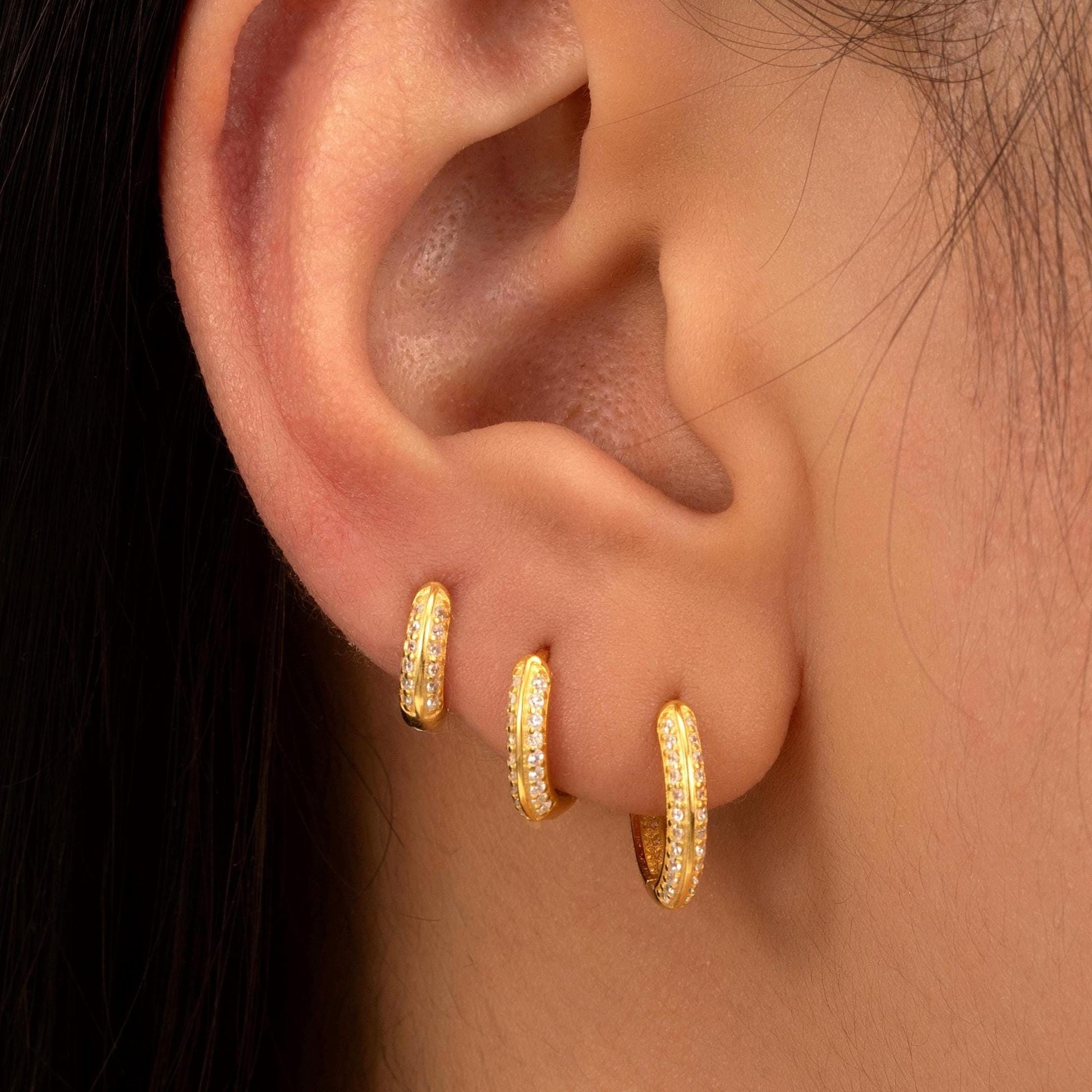 a close up of a person wearing a pair of earrings