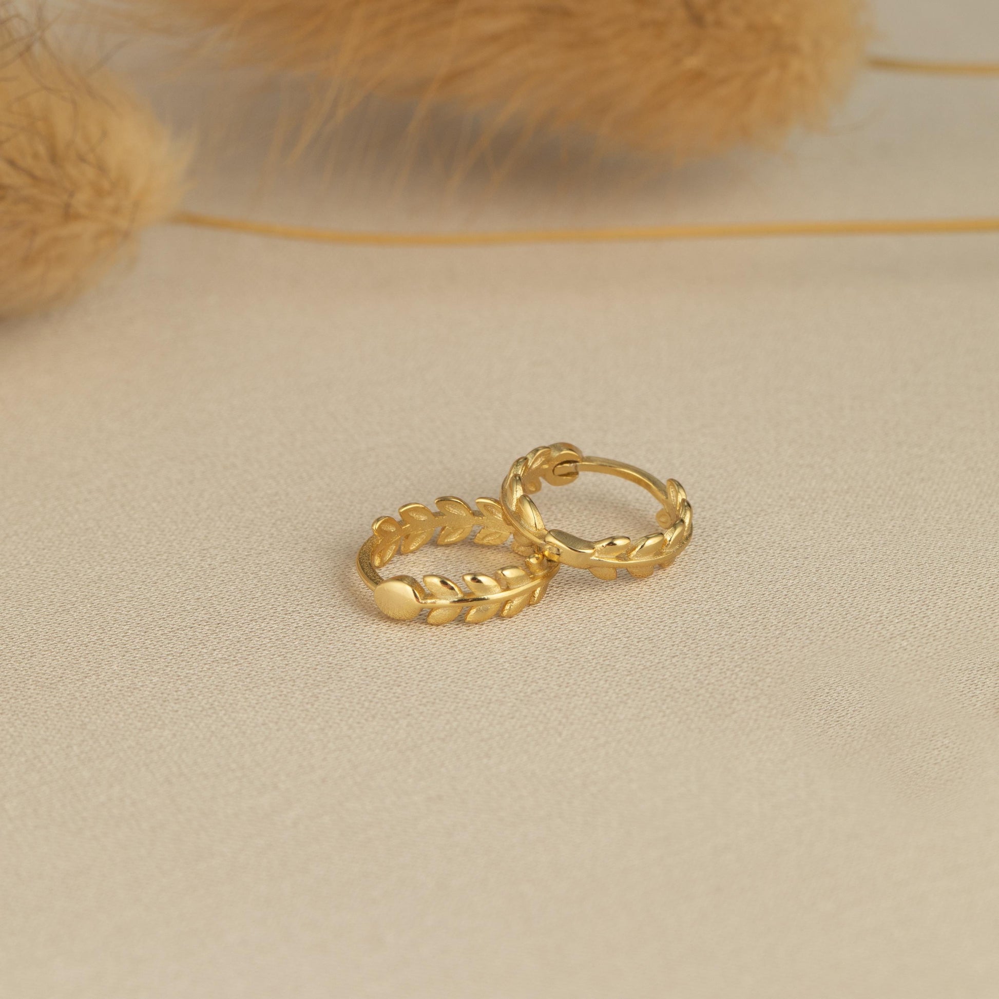 a pair of gold rings sitting on top of a table