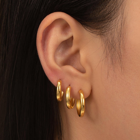 a close up of a person wearing a pair of earrings