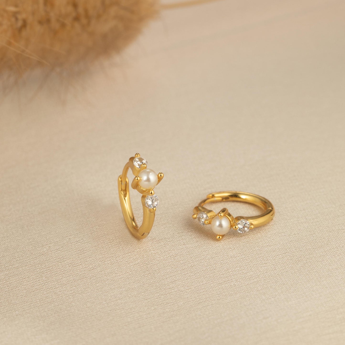 a pair of gold rings sitting on top of a table