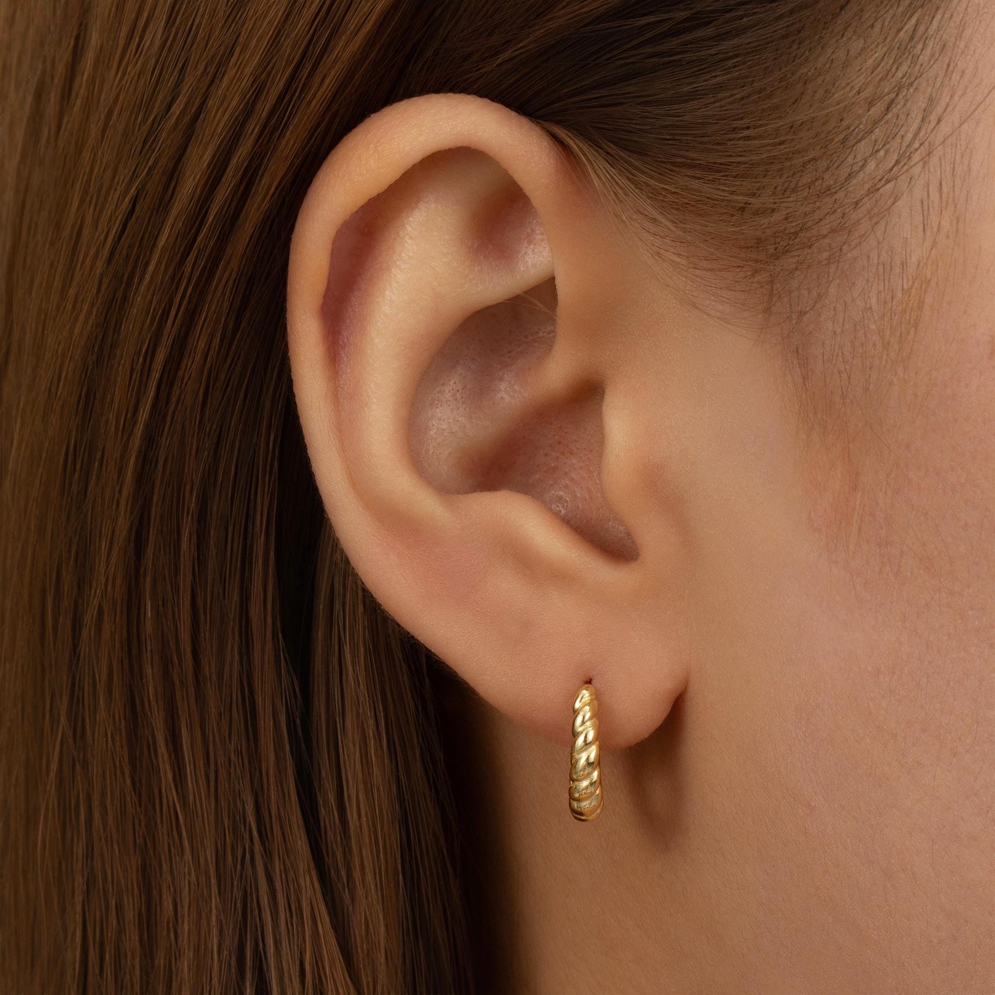 a close up of a person wearing a pair of earrings