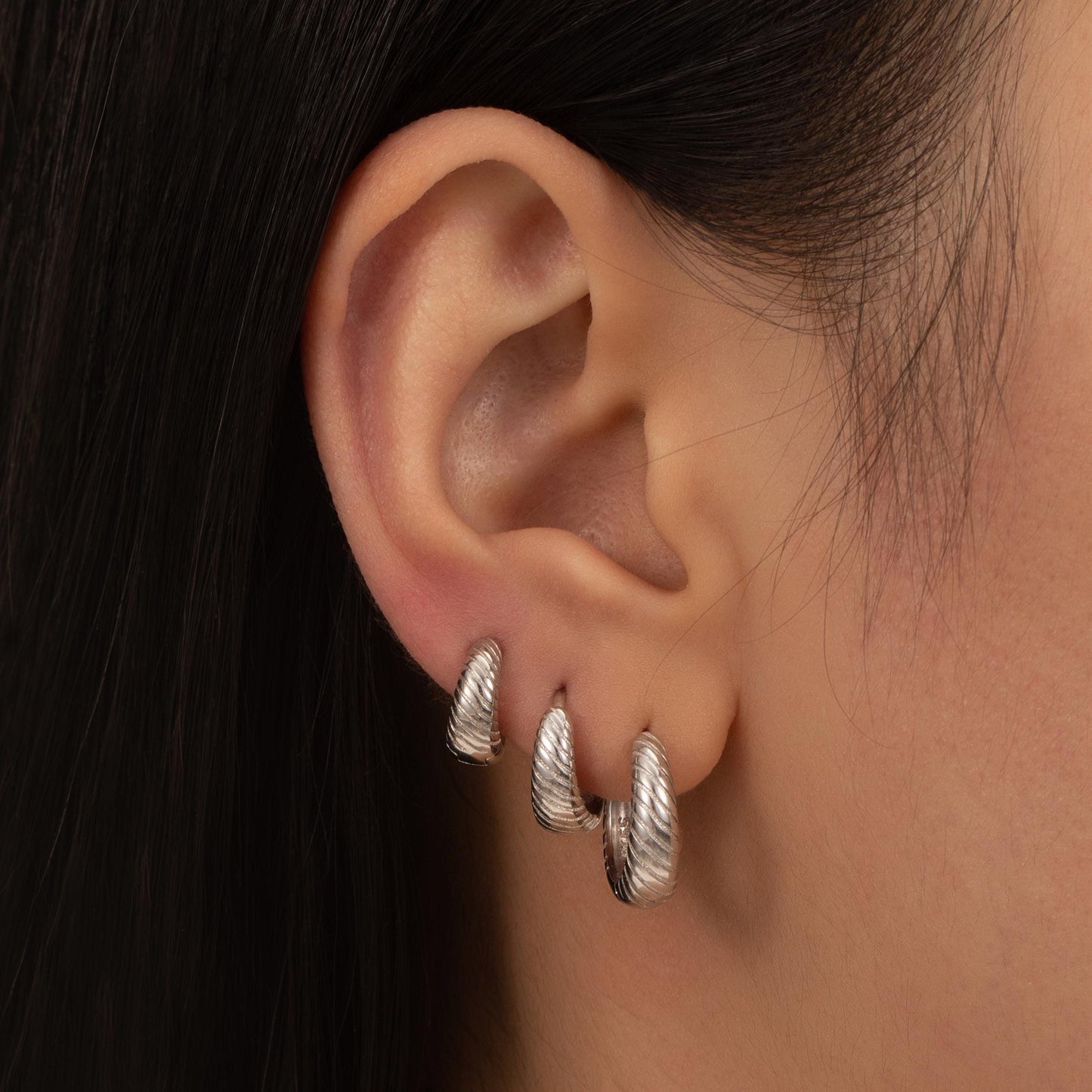 a close up of a person wearing a pair of earrings