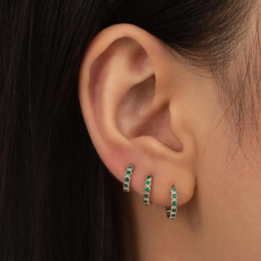 a close up of a person wearing a pair of earrings