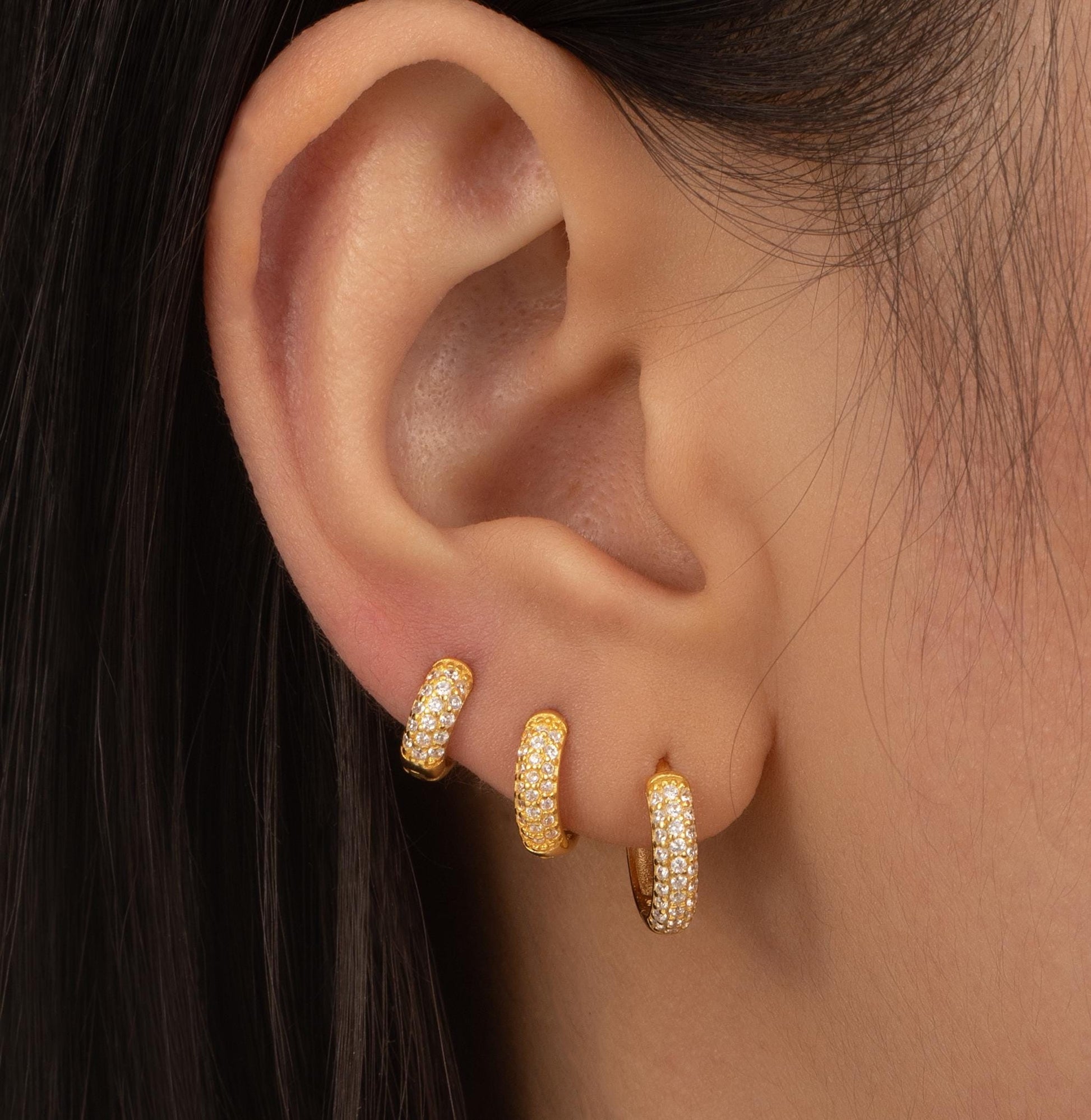 a close up of a person wearing a pair of earrings