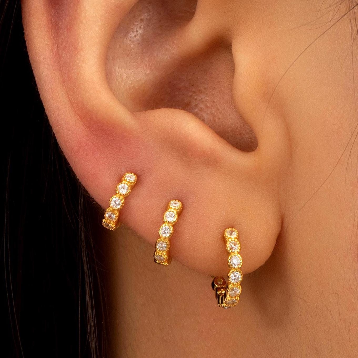 a close up of a person wearing a pair of earrings