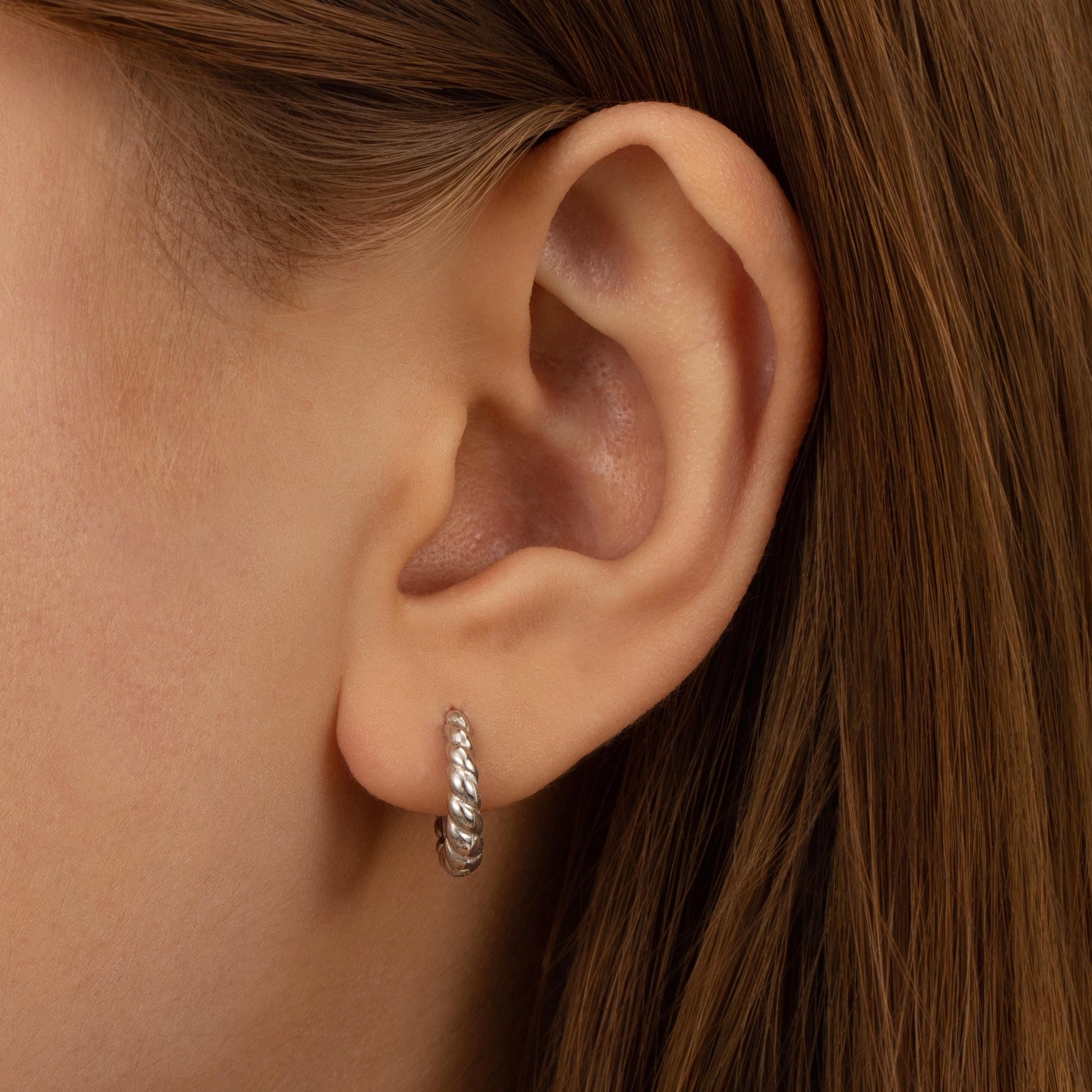 a close up of a person wearing a pair of earrings