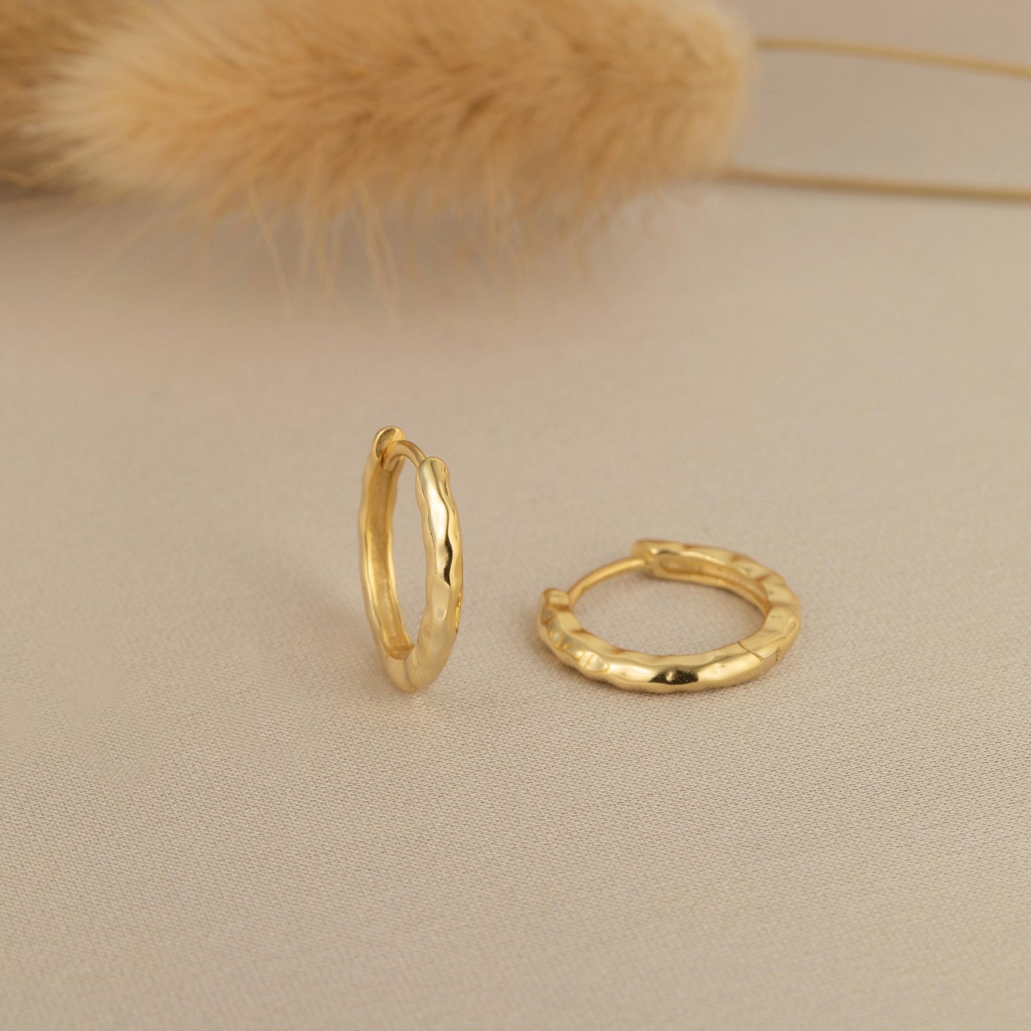 a pair of gold rings sitting on top of a table