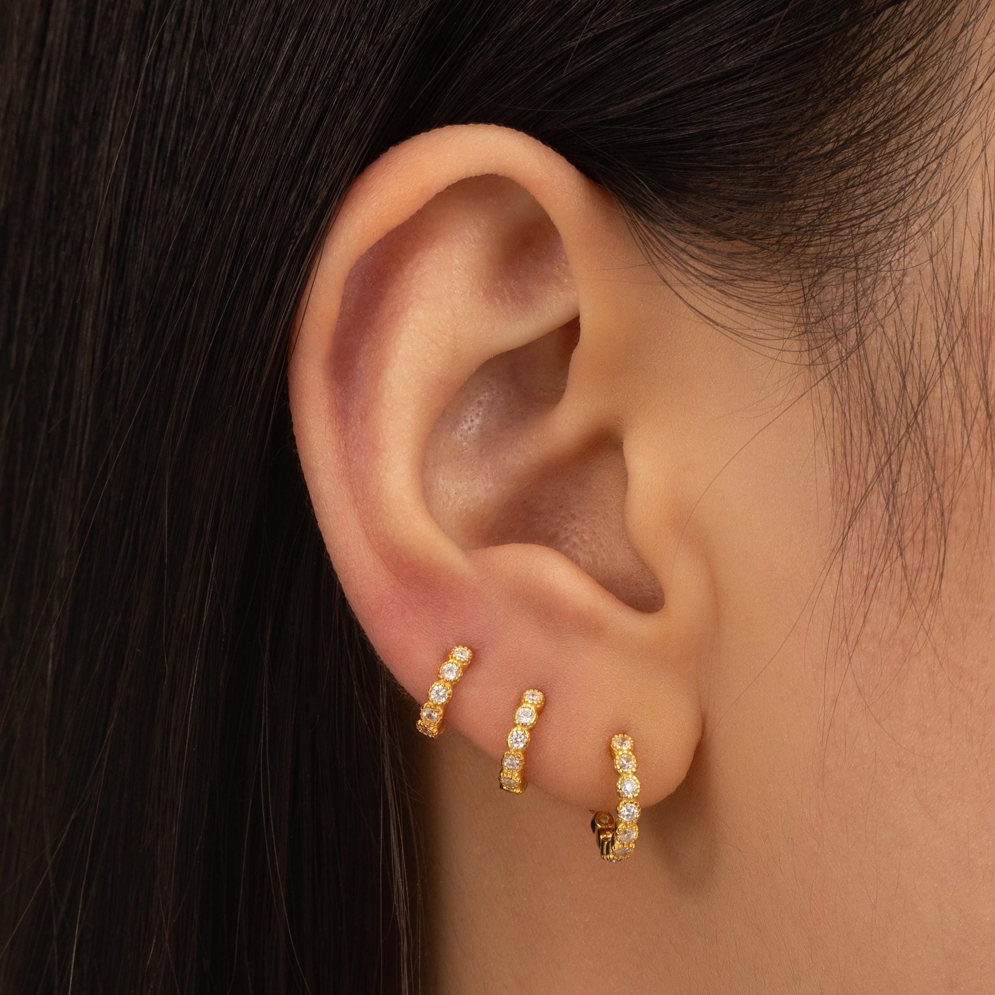 a close up of a person wearing a pair of earrings