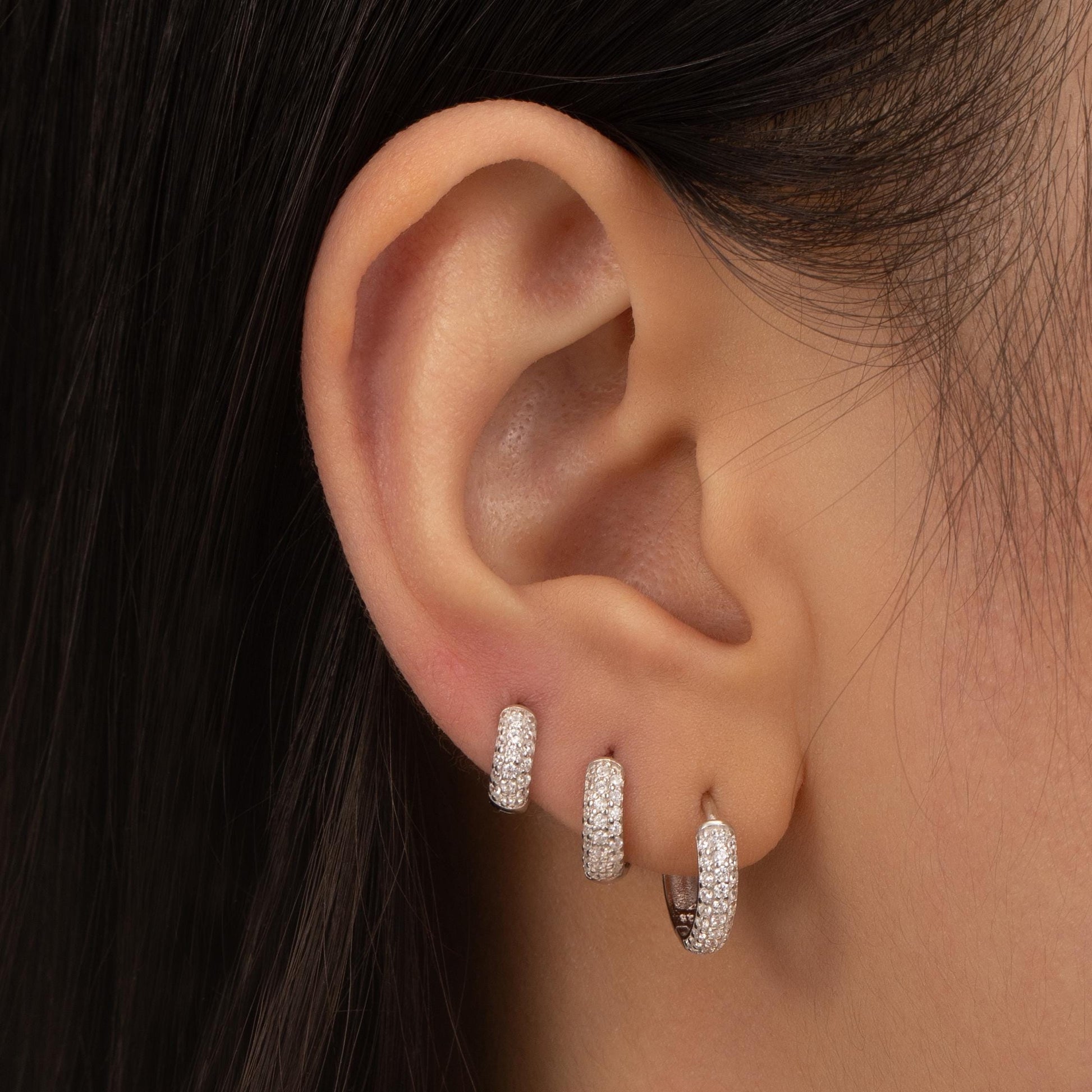 a close up of a person wearing a pair of earrings