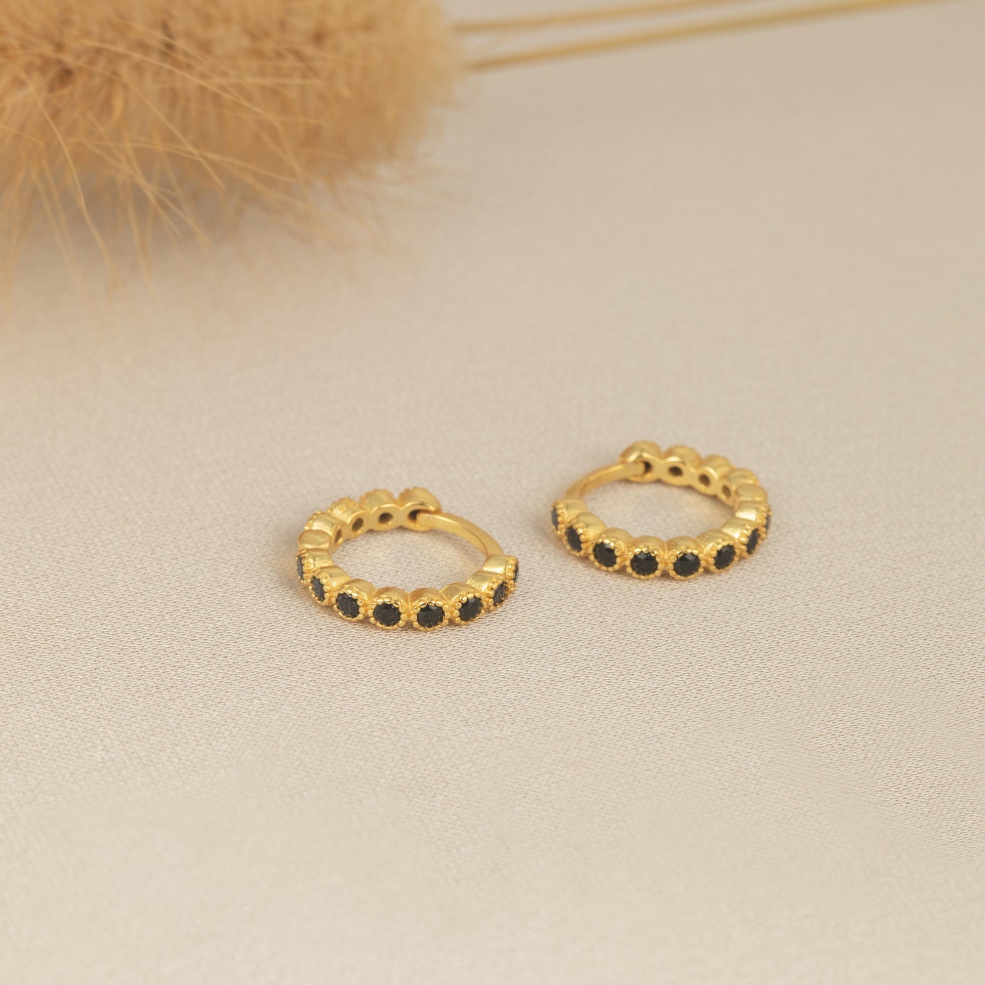 a pair of small black diamond hoop earrings