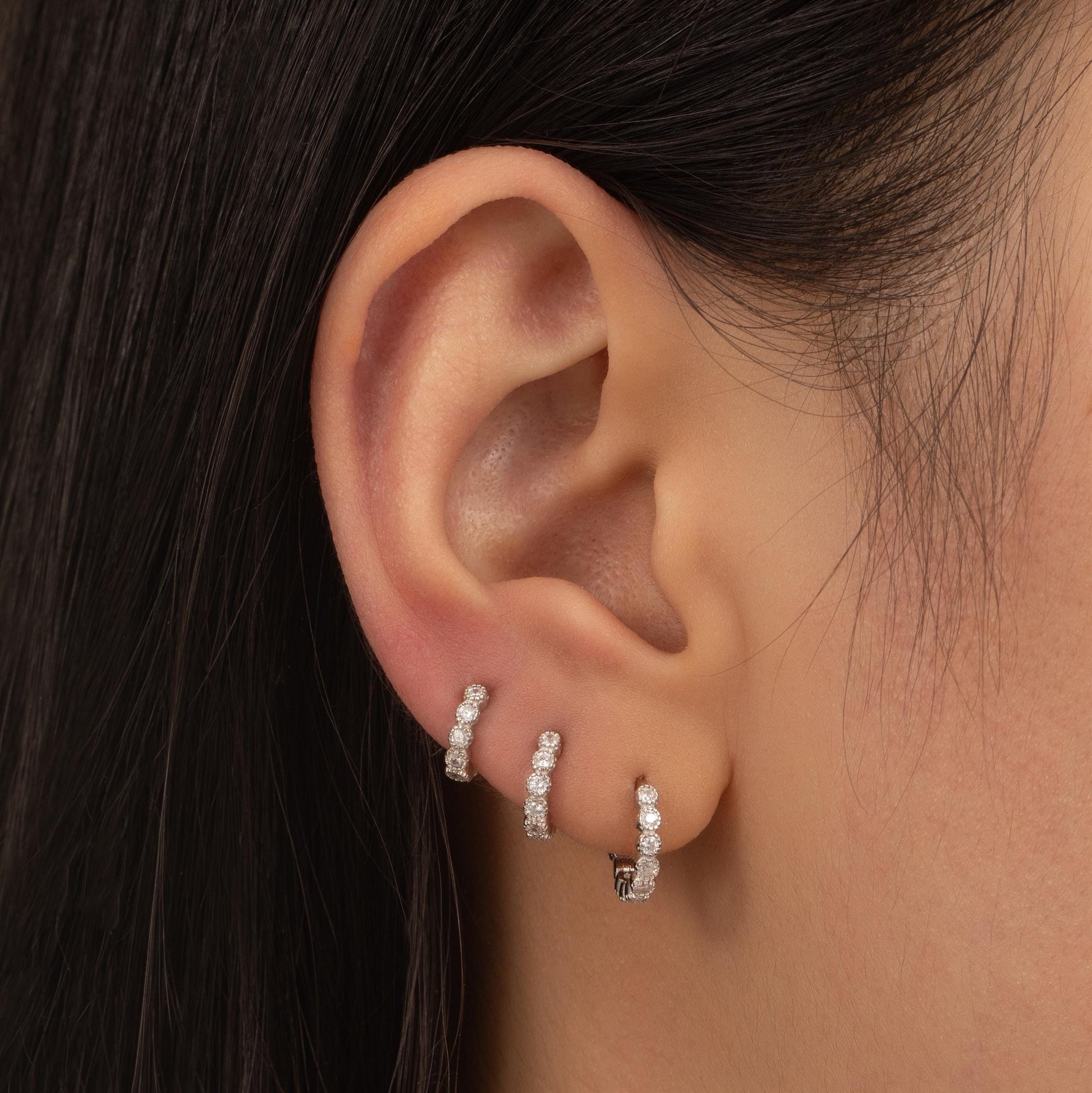 a close up of a person wearing a pair of earrings