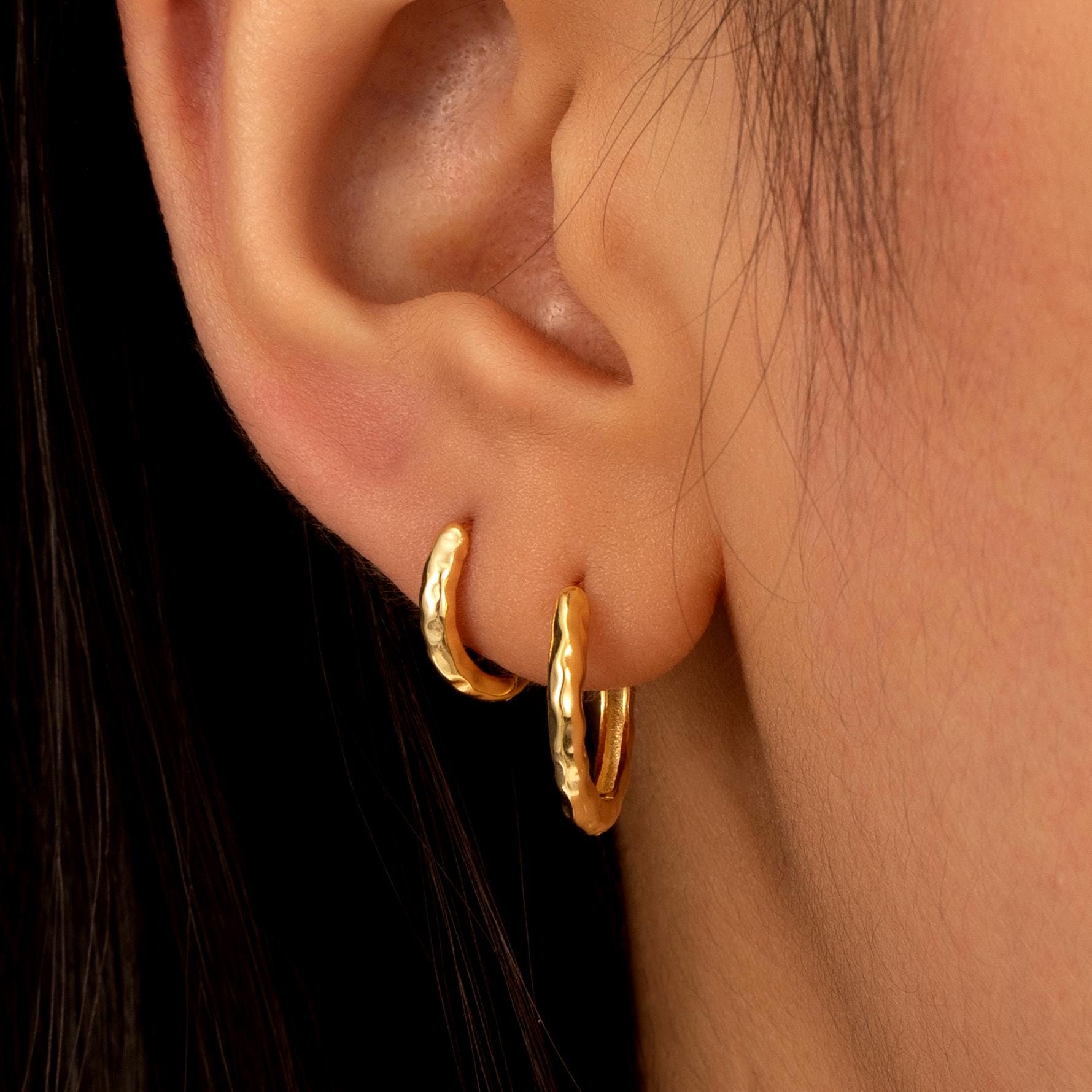 a close up of a person wearing a pair of earrings