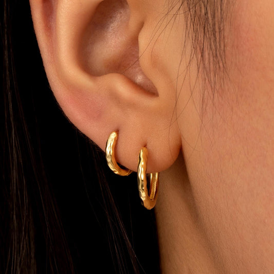 a close up of a person wearing a pair of earrings