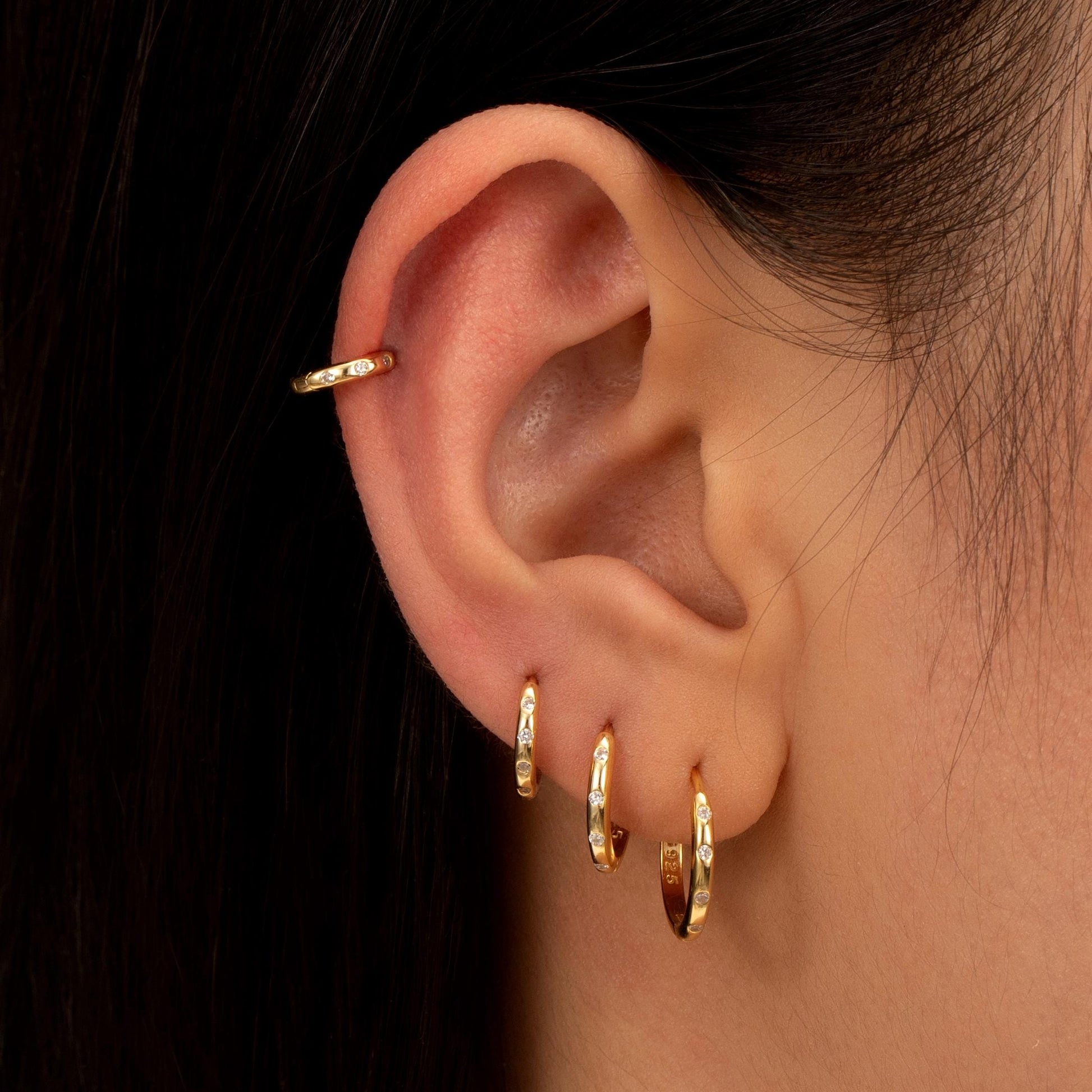 a close up of a person wearing a pair of earrings