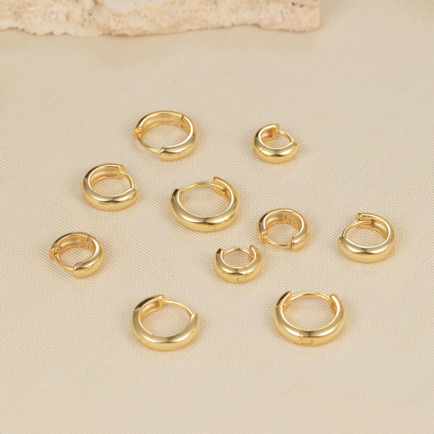 a bunch of gold colored rings on a white surface