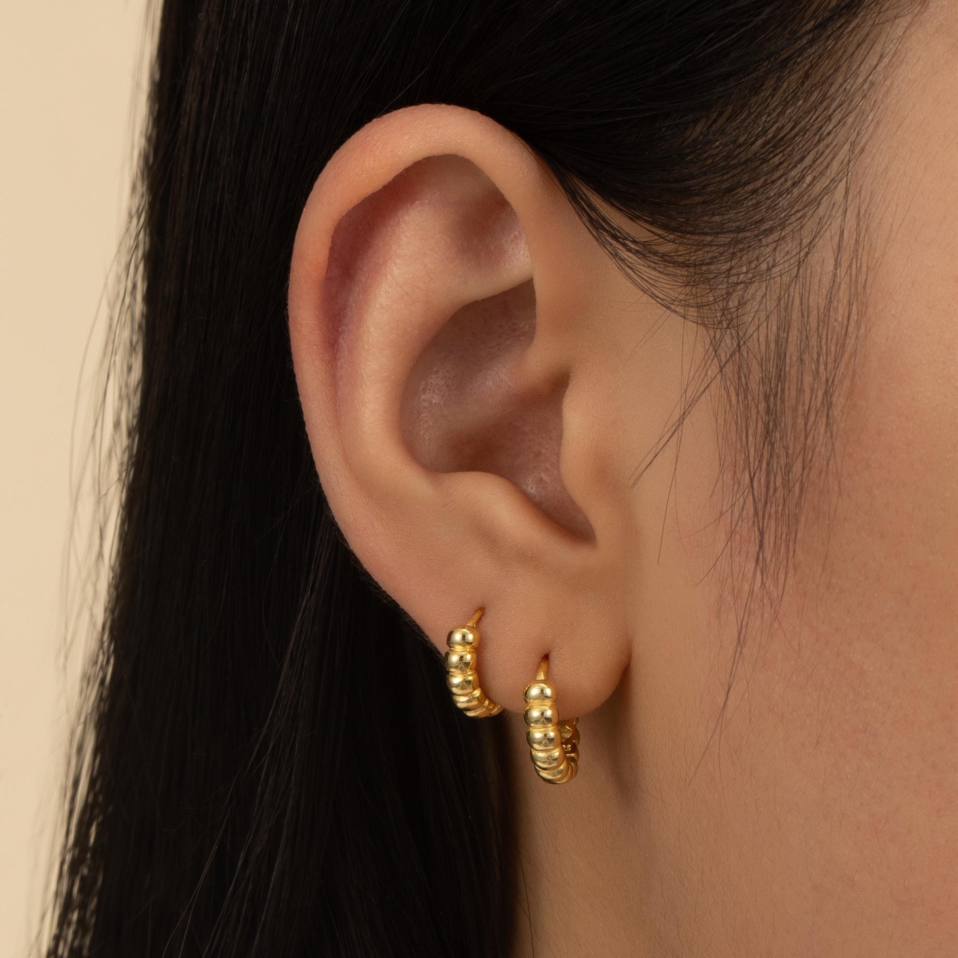 a close up of a person wearing a pair of earrings