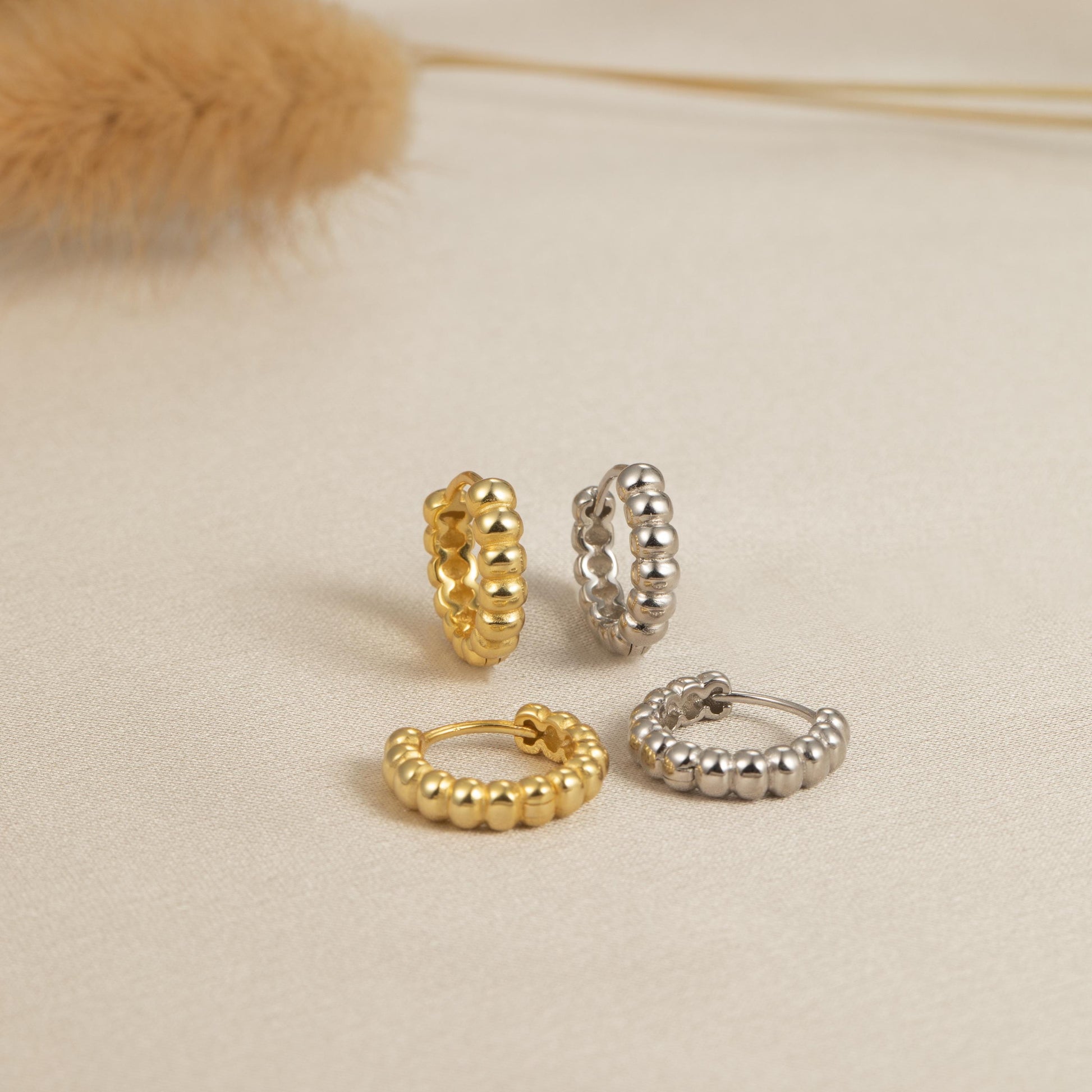 three pairs of gold, silver, and diamond hoop earrings